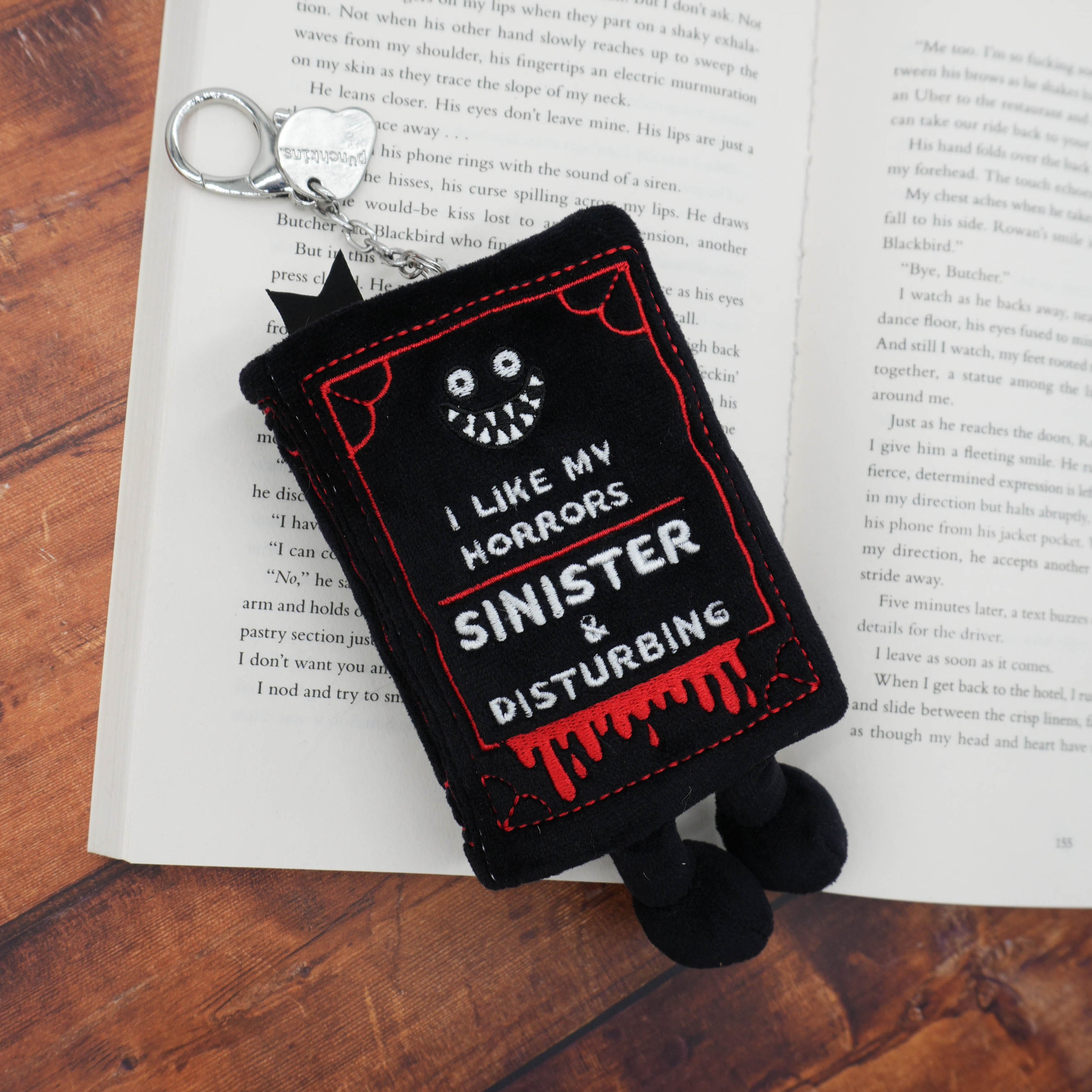Horror book-themed bag charm on an open book