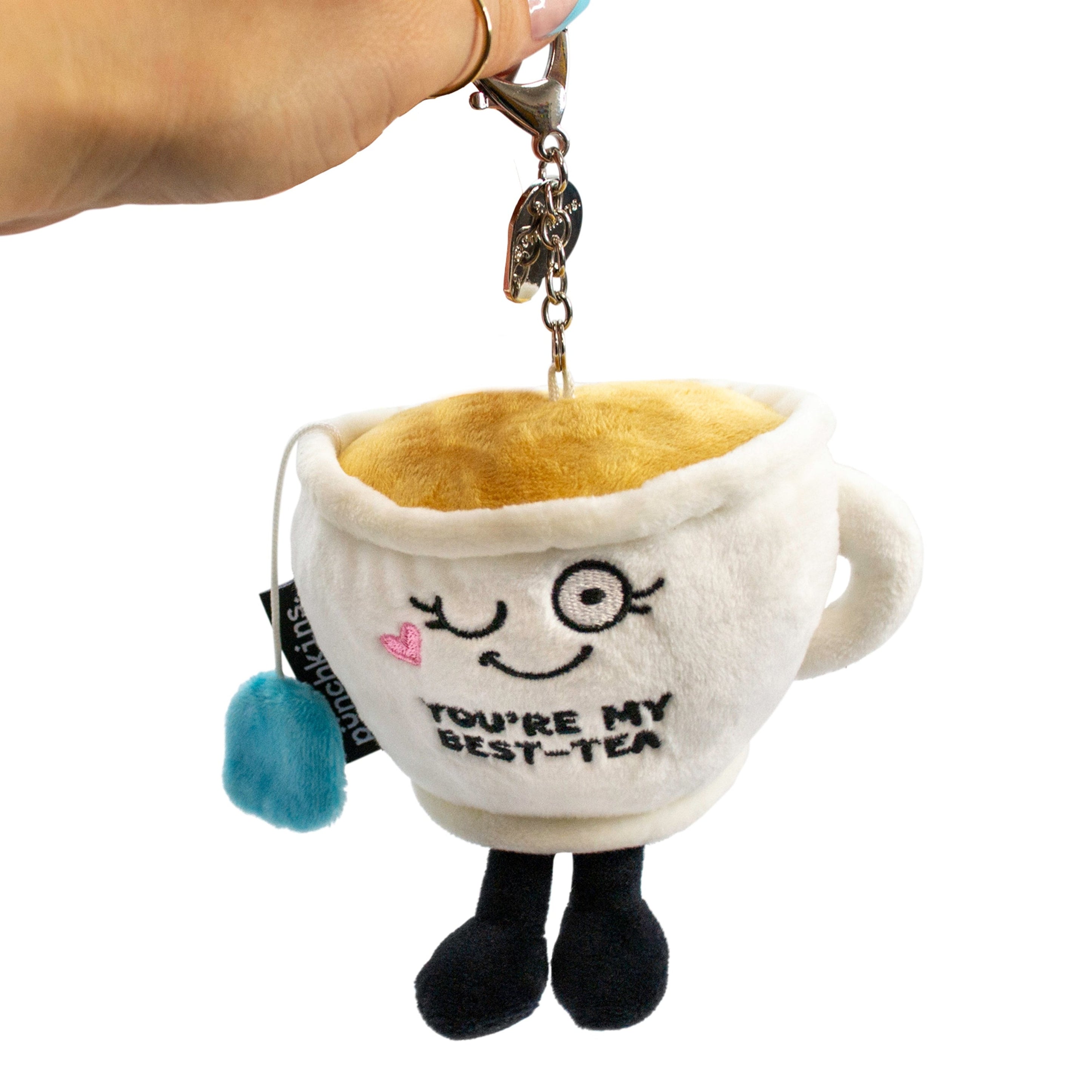 A plush teacup bag charm with a cute face and 'you're my best-tea' text embroidered on it.