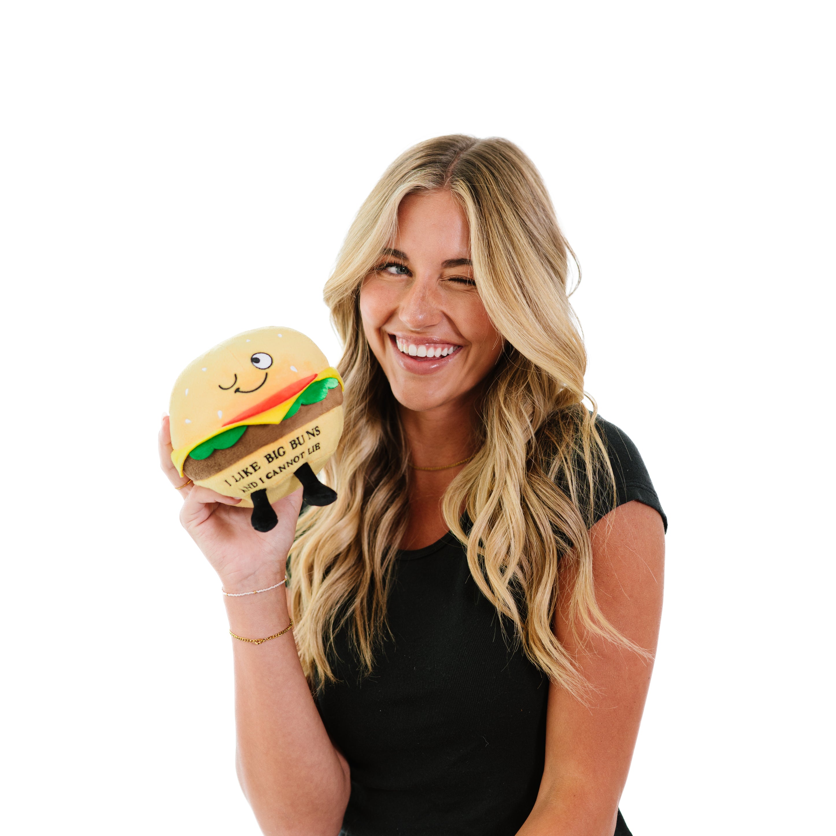A blonde holding a plush cheeseburger with "I like big buns and I cannot lie" printed on it