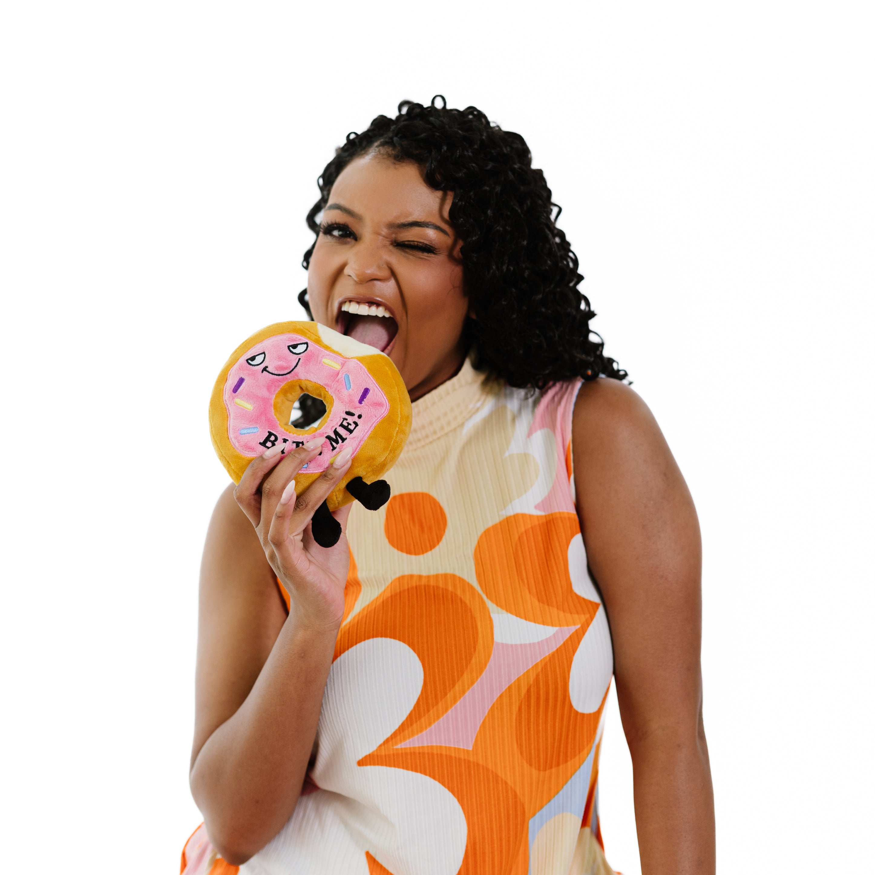 A model holding a plush donut that reads, 'bite me.'