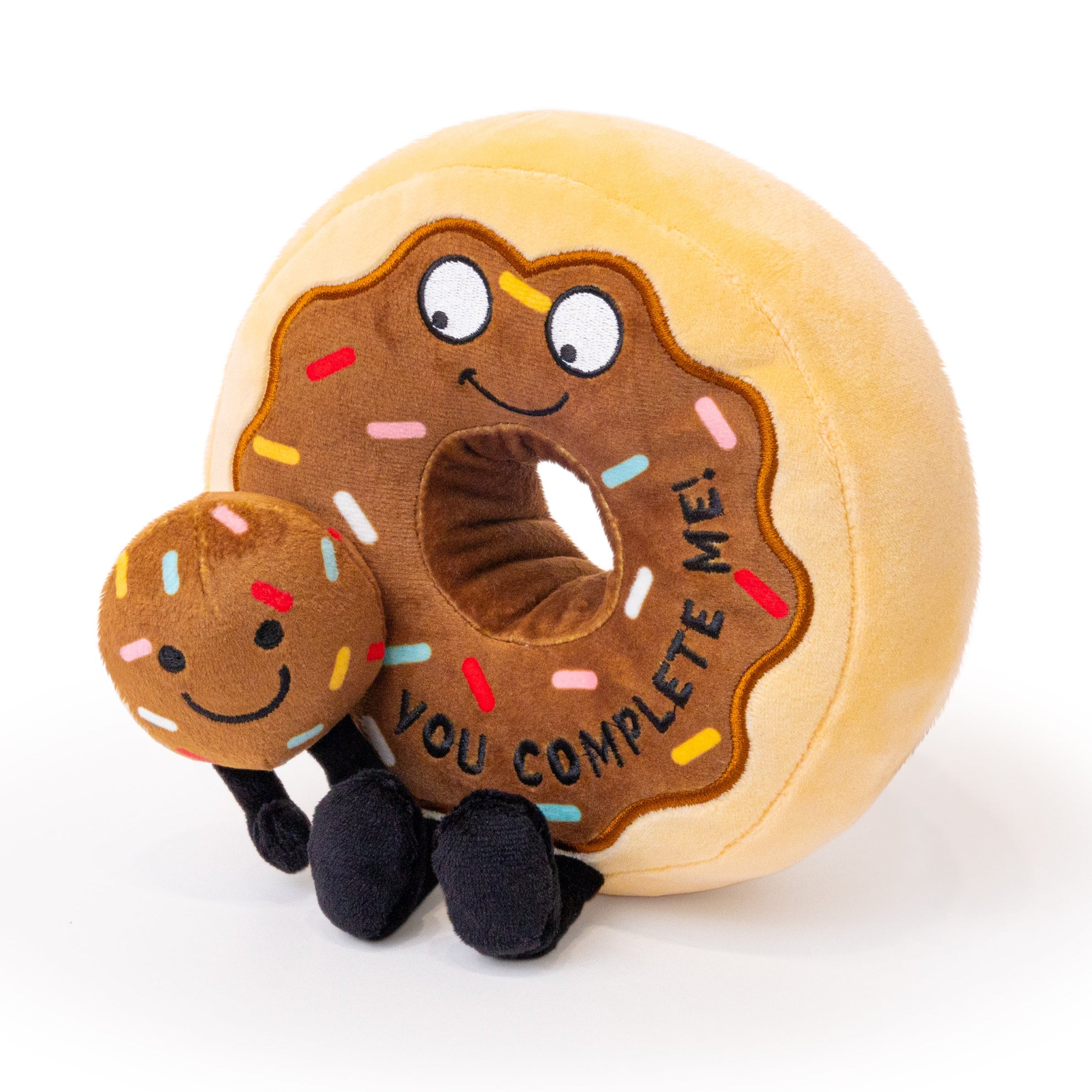 A plush donut and a donut hole with the phrase 'You Complete Me' printed on it.