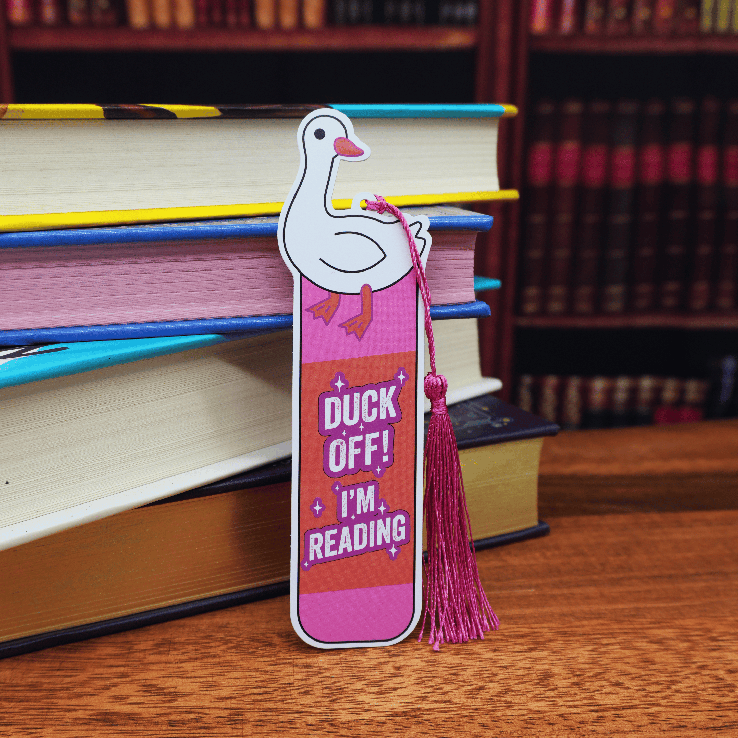 Bookmark with duck illustration and text 'Duck off! I'm reading' on a stack of books.