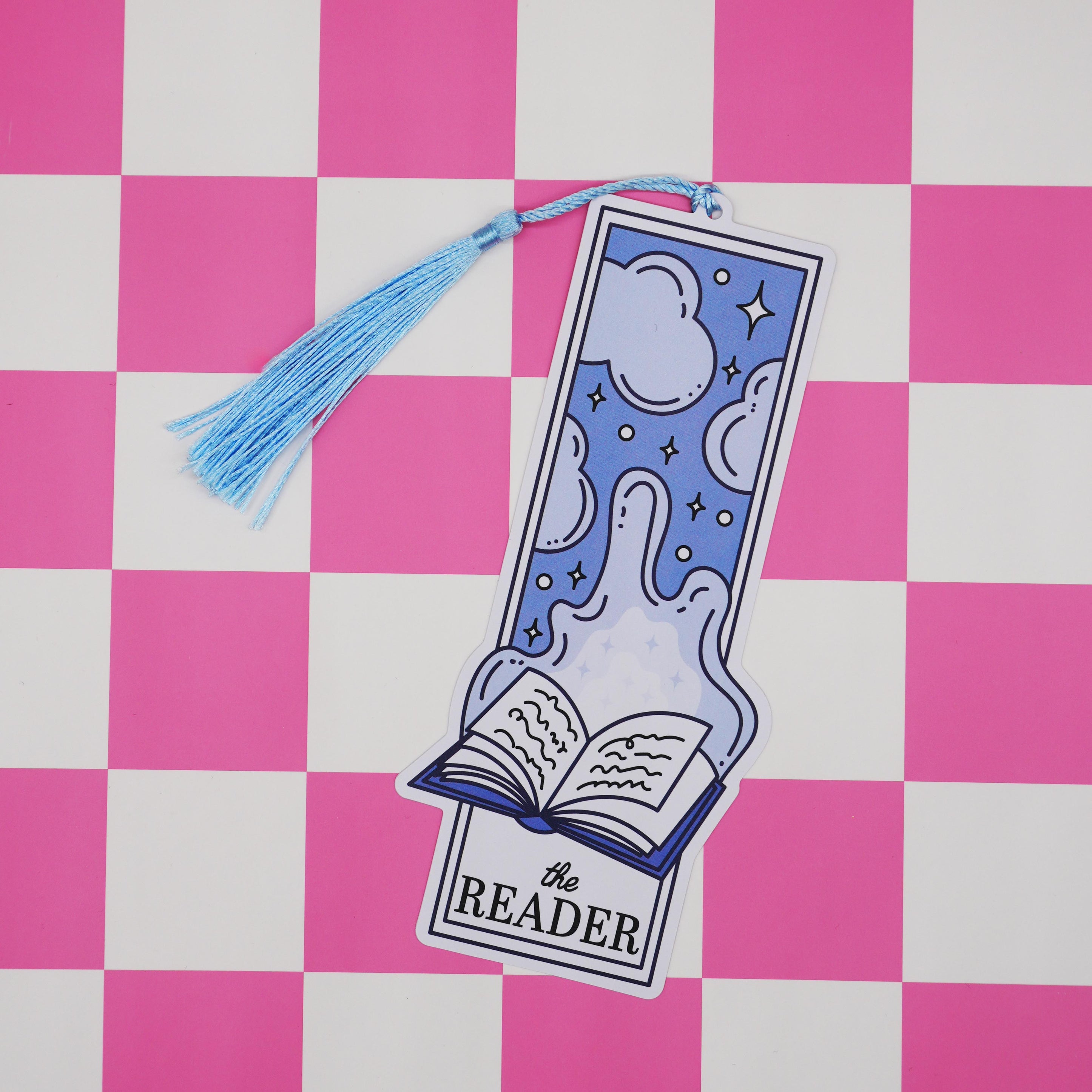 The reader bookmark with tassel on a pink and white checkered background