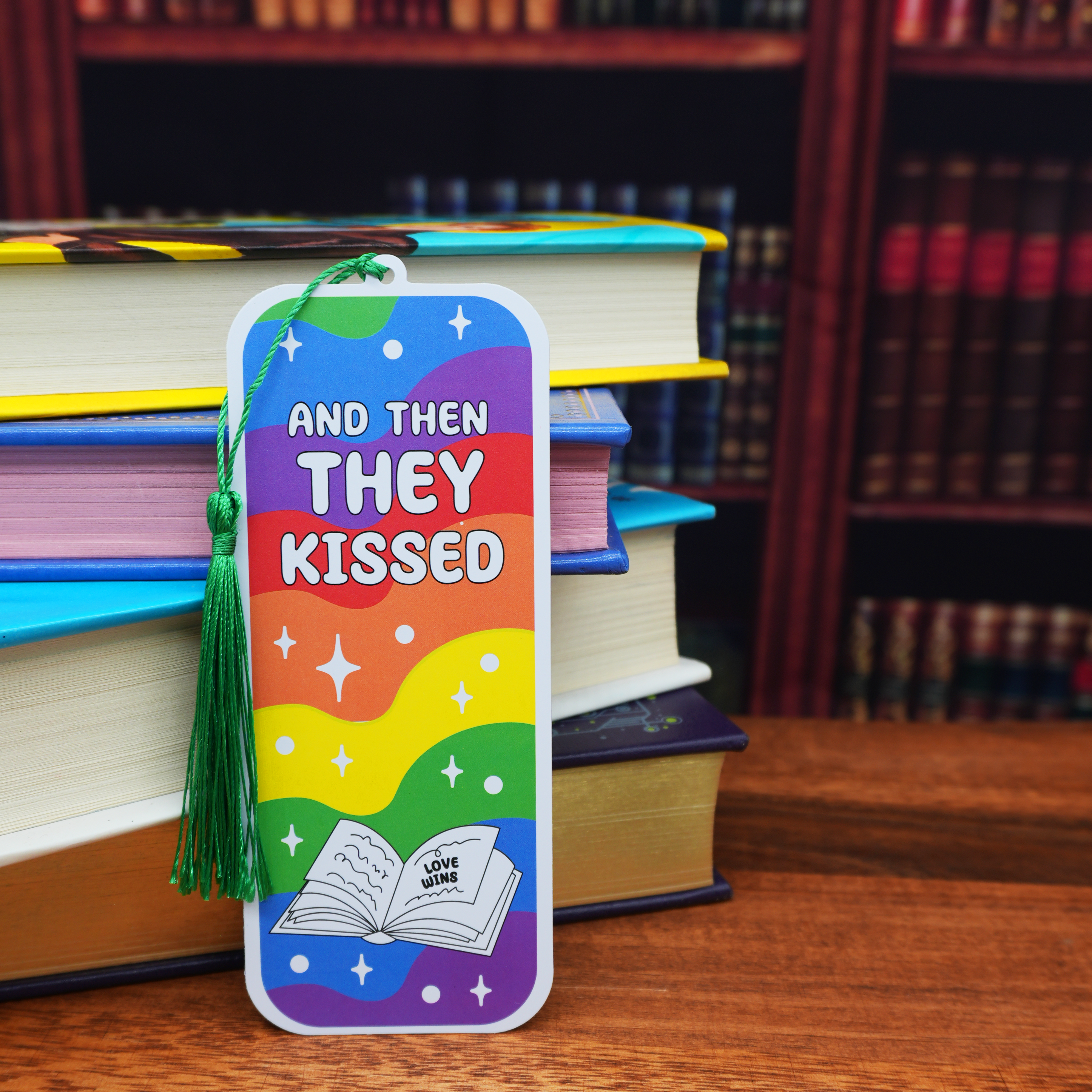 Colorful bookmark with 'And Then They Kissed' text on a stack of books.