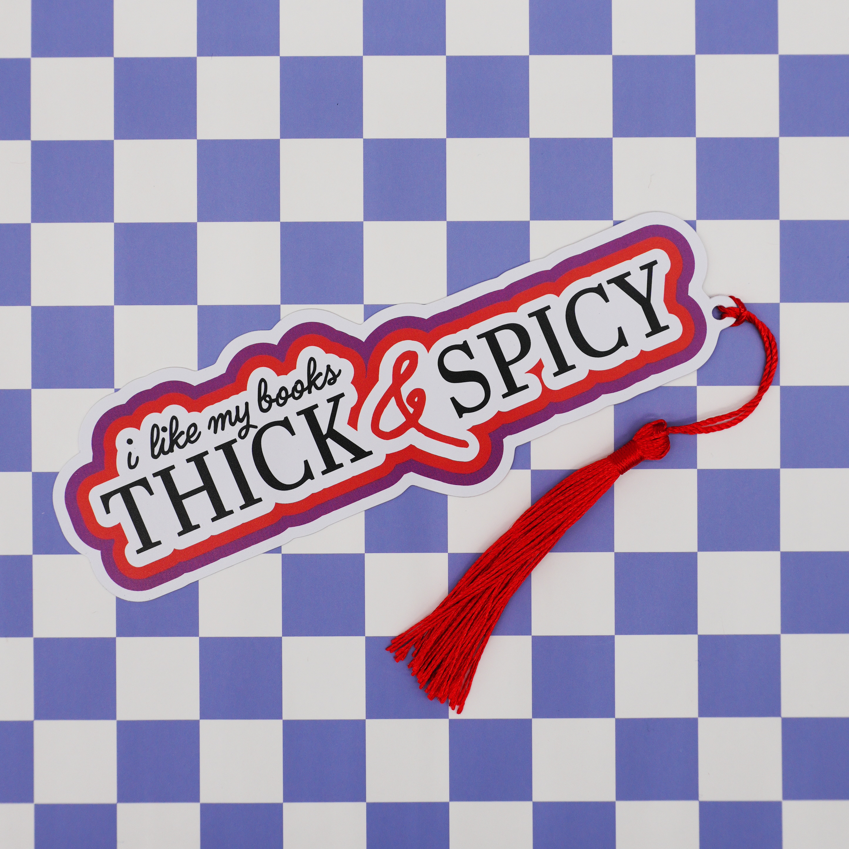 Bookmark with 'i like my books Thick & Spicy' text on a blue and white checkered background