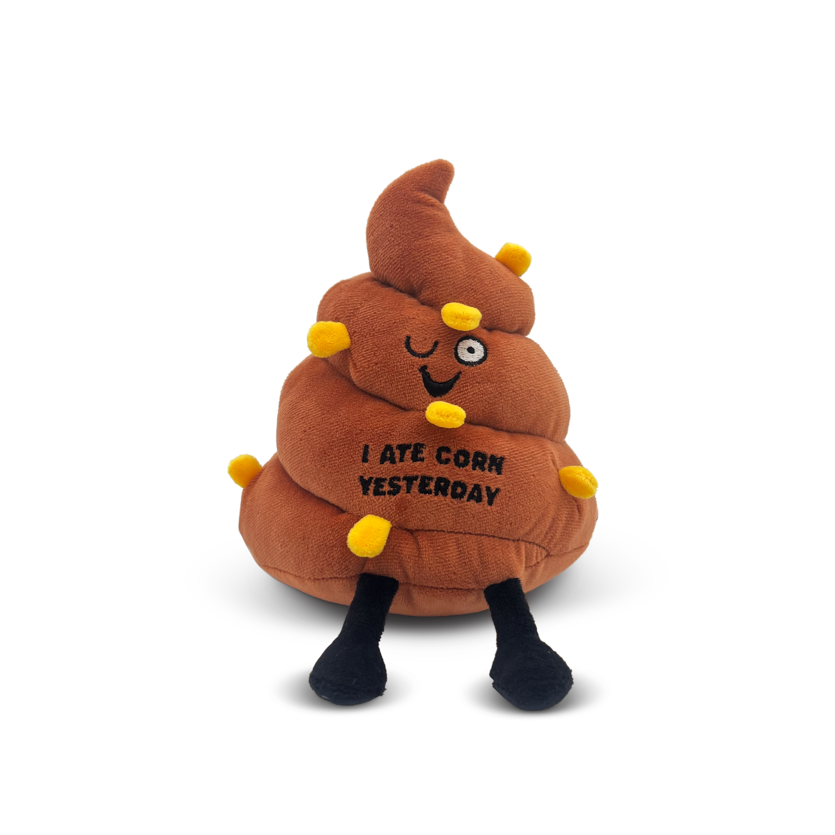A plush poop with a smiling face, pieces of corn sewn in, and text that reads 'I ATE CORN YESTERDAY.'