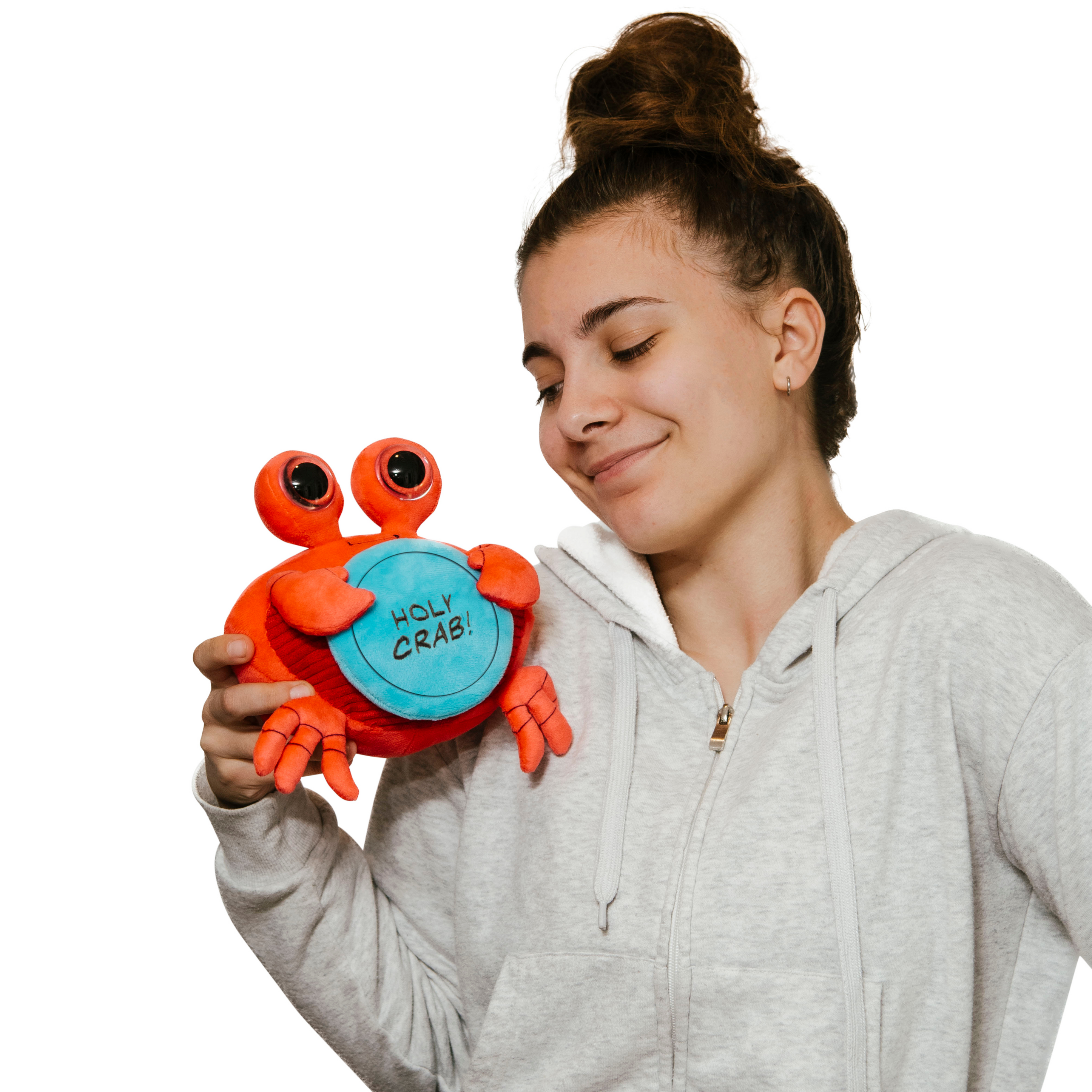 A woman holding a plush shaped like a crab holding a sign with the text 'HOLY CRAB!'