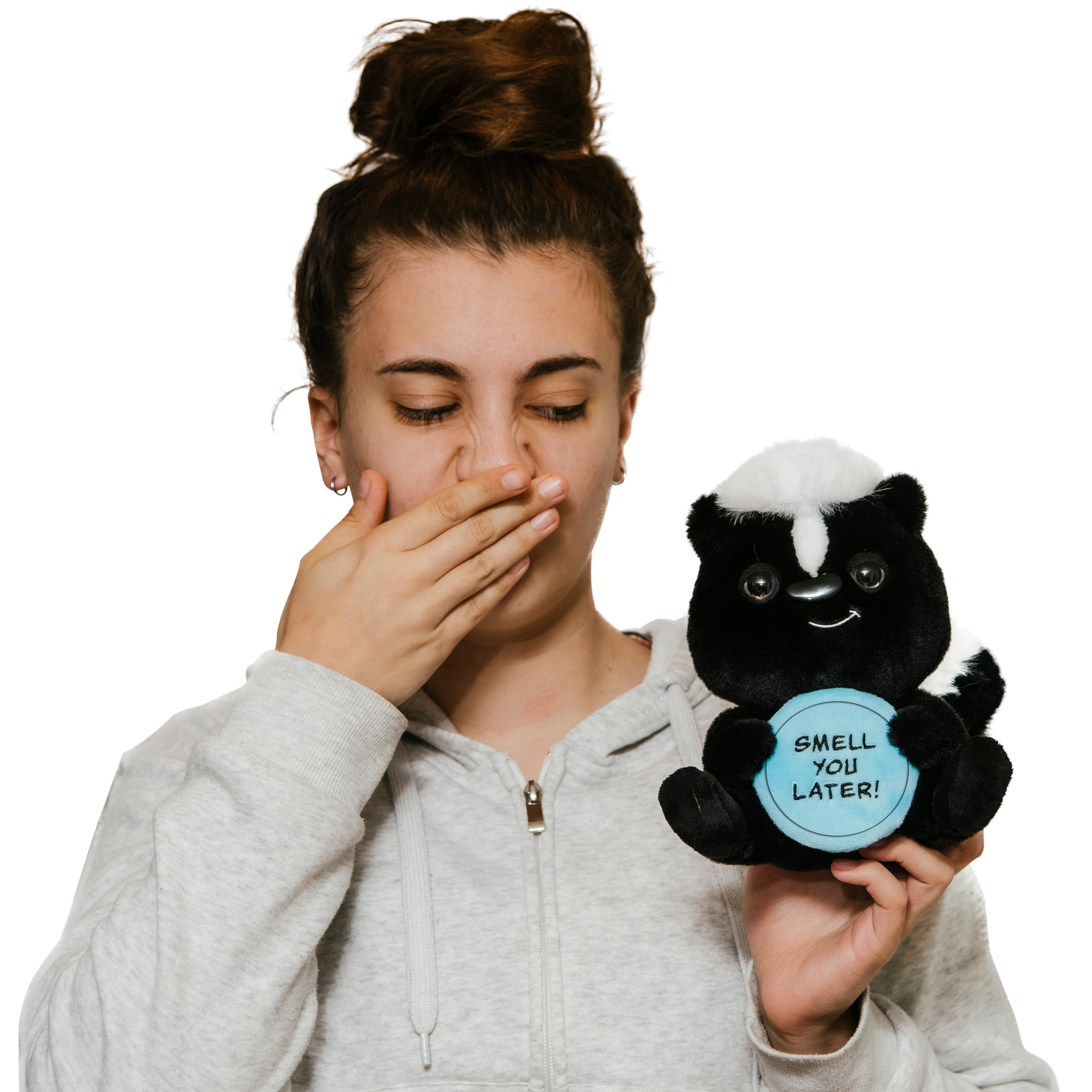 A woman holding a plush resembling a skunk holding a sign that reads 'SMELL YOU LATER'.