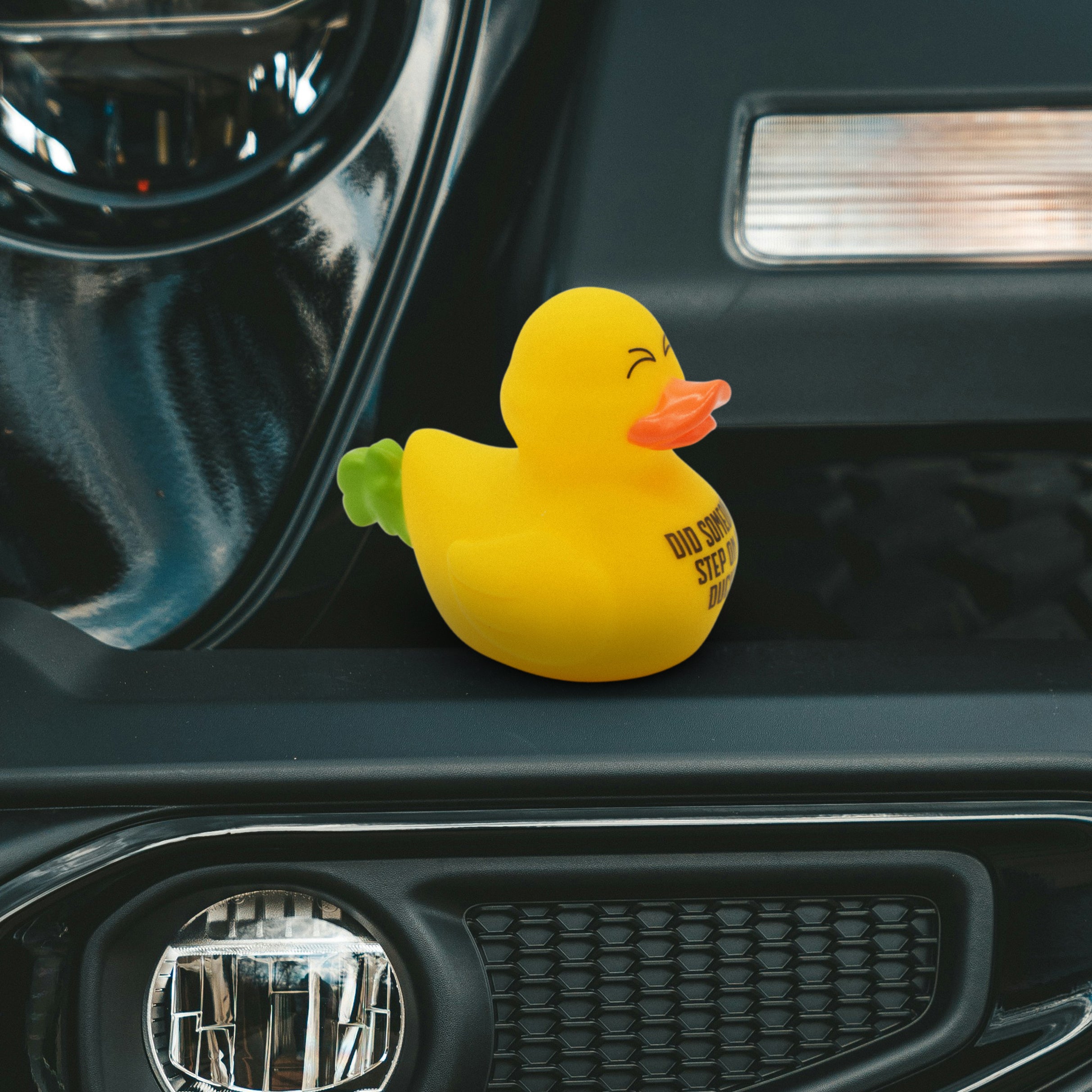 Yellow rubber duck farting with text 'Did someone step on a duck?' on a car dashboard.