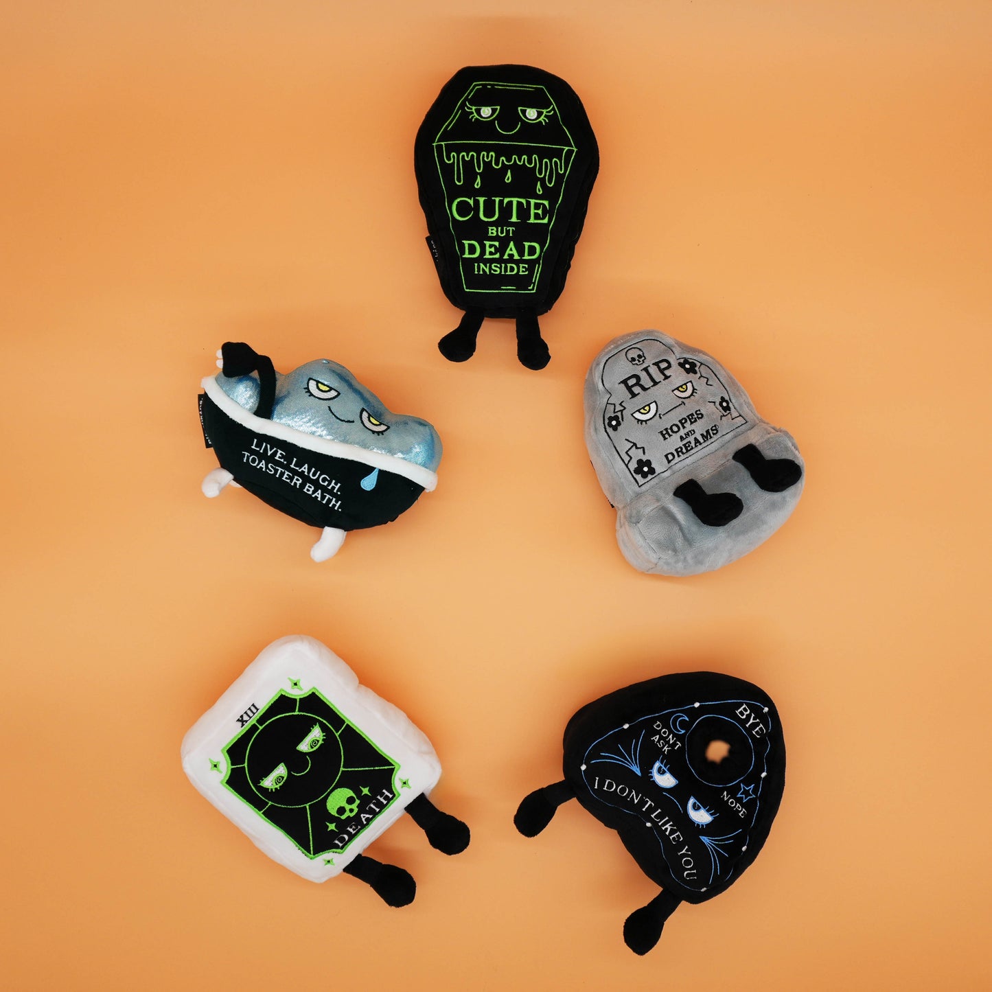 Five Halloween-themed plush toys on an orange background