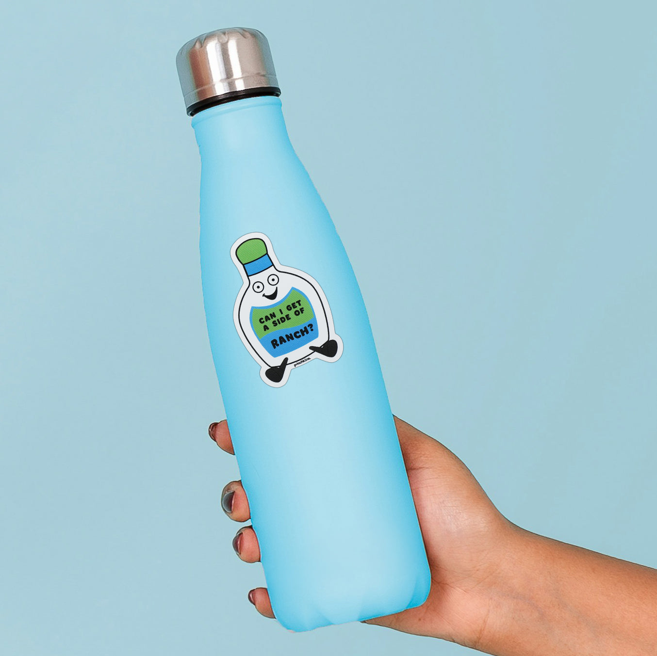 A light blue insulated water bottle with a stainless steel cap, held in a hand against a solid light blue background. The bottle features a ranch cartoon graphic holding a sign that reads 'CAN I GET A SIDE OF RANCH?'.