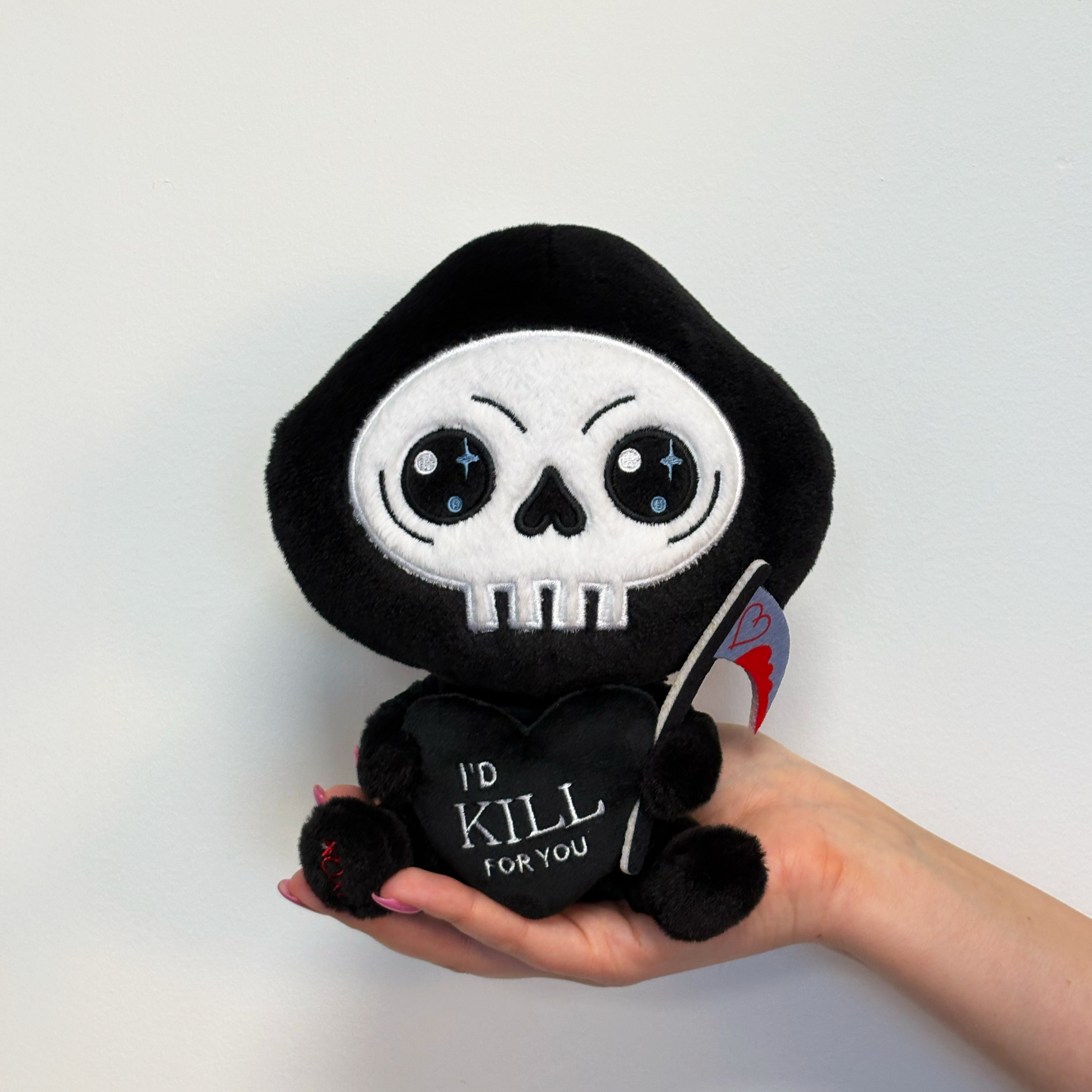 Hand holding grim reaper plush