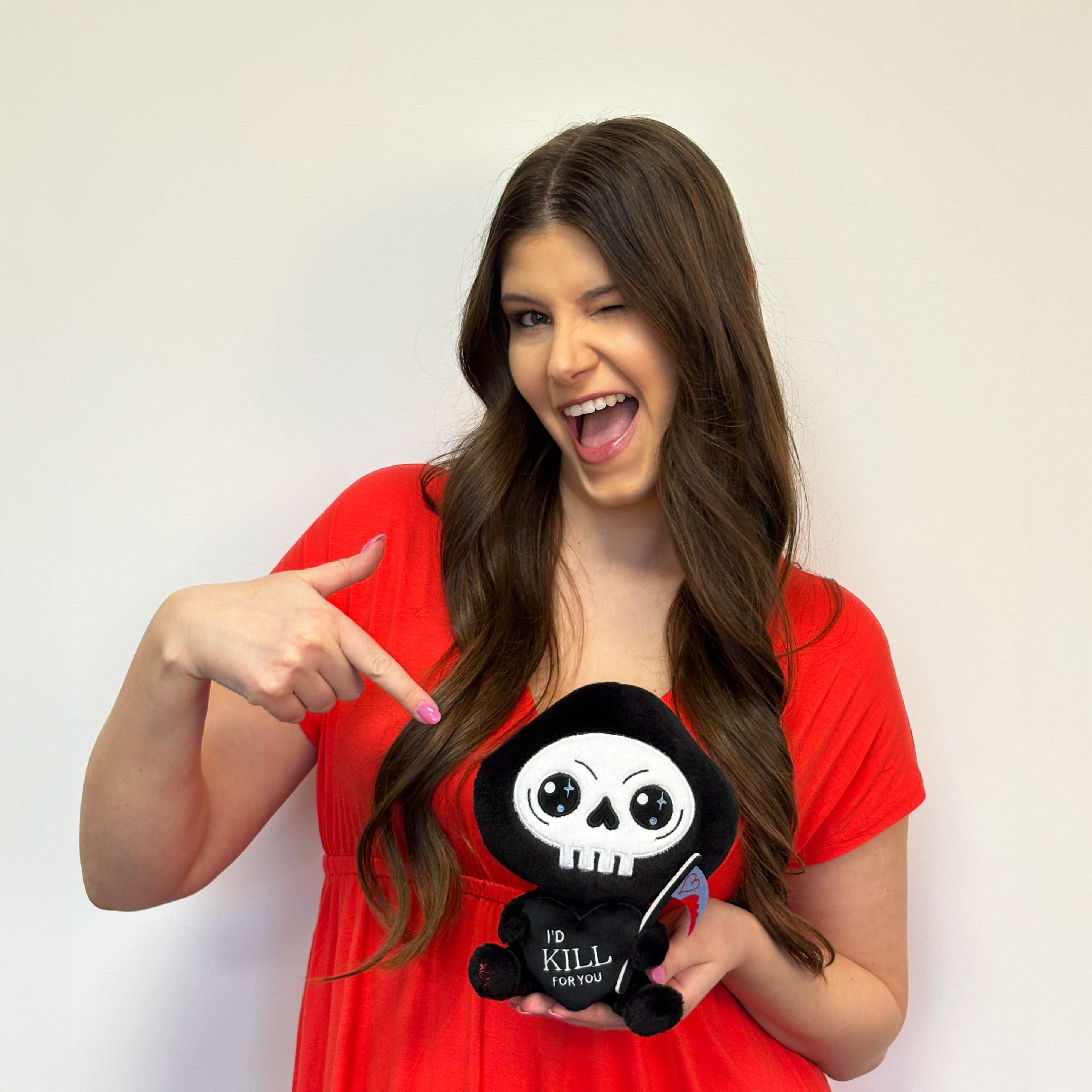 Brunette woman holding grim reaper plush that says I'd kill for you