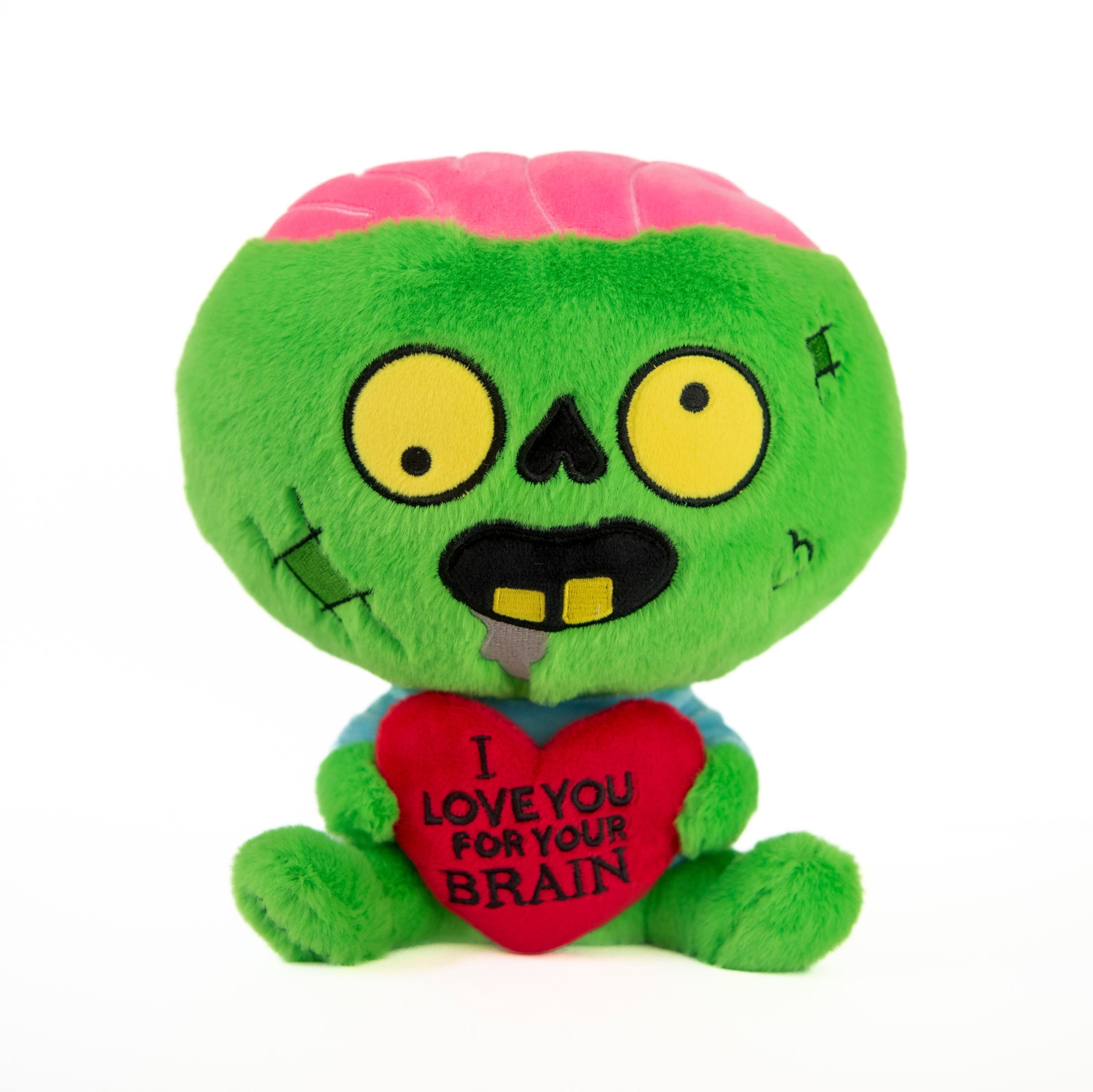A plush toy resembling a zombie with a bright pink brain and an inverted heart nose, holding a red heart that says 'I love you for your brains'.