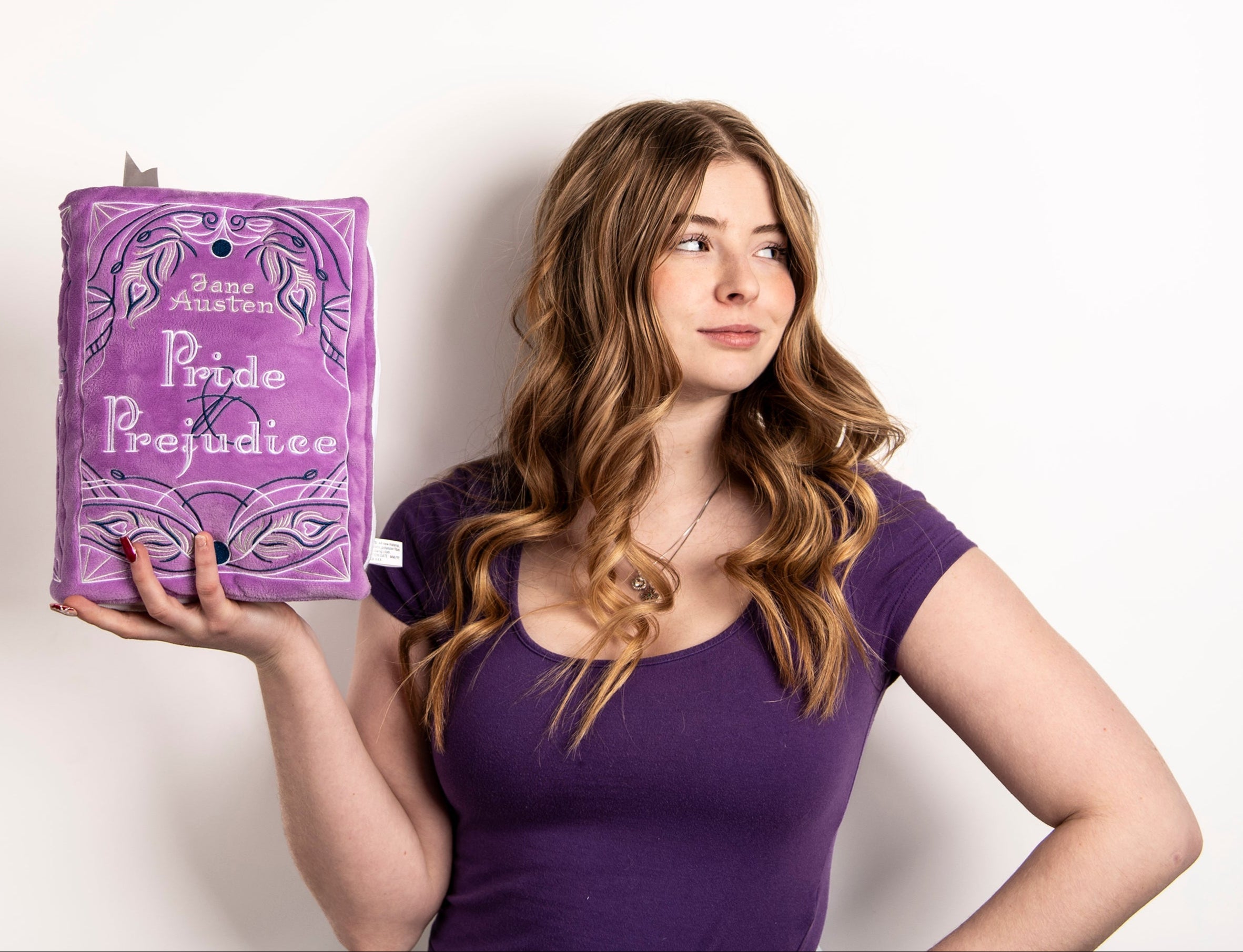 Woman holding the pride and prejudice book plushie 