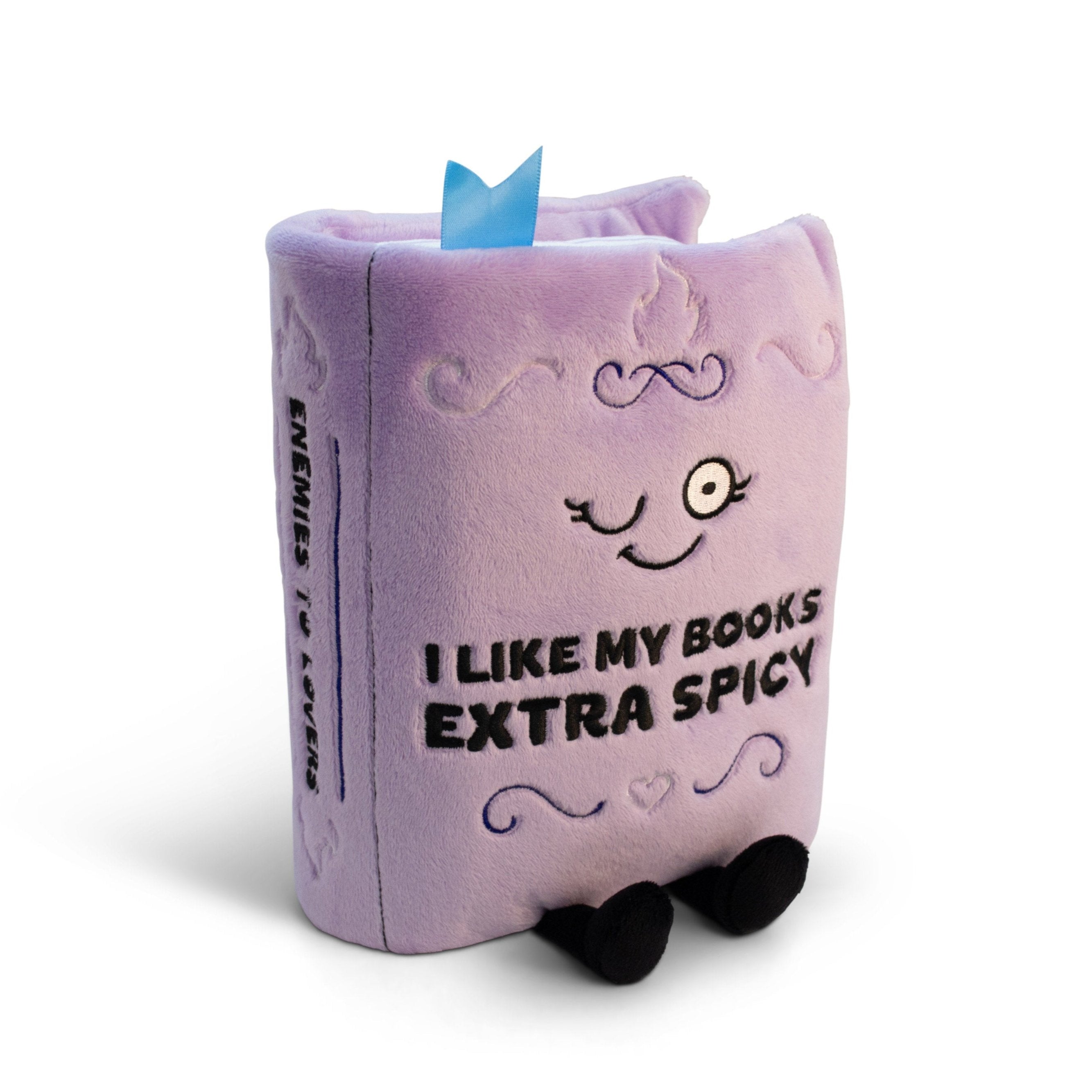 A plush book with the phrase 'I LIKE MY BOOKS EXTRA SPICY' written on the cover, with a blue bookmark, black standoffs, and a smiling face illustration on the front.