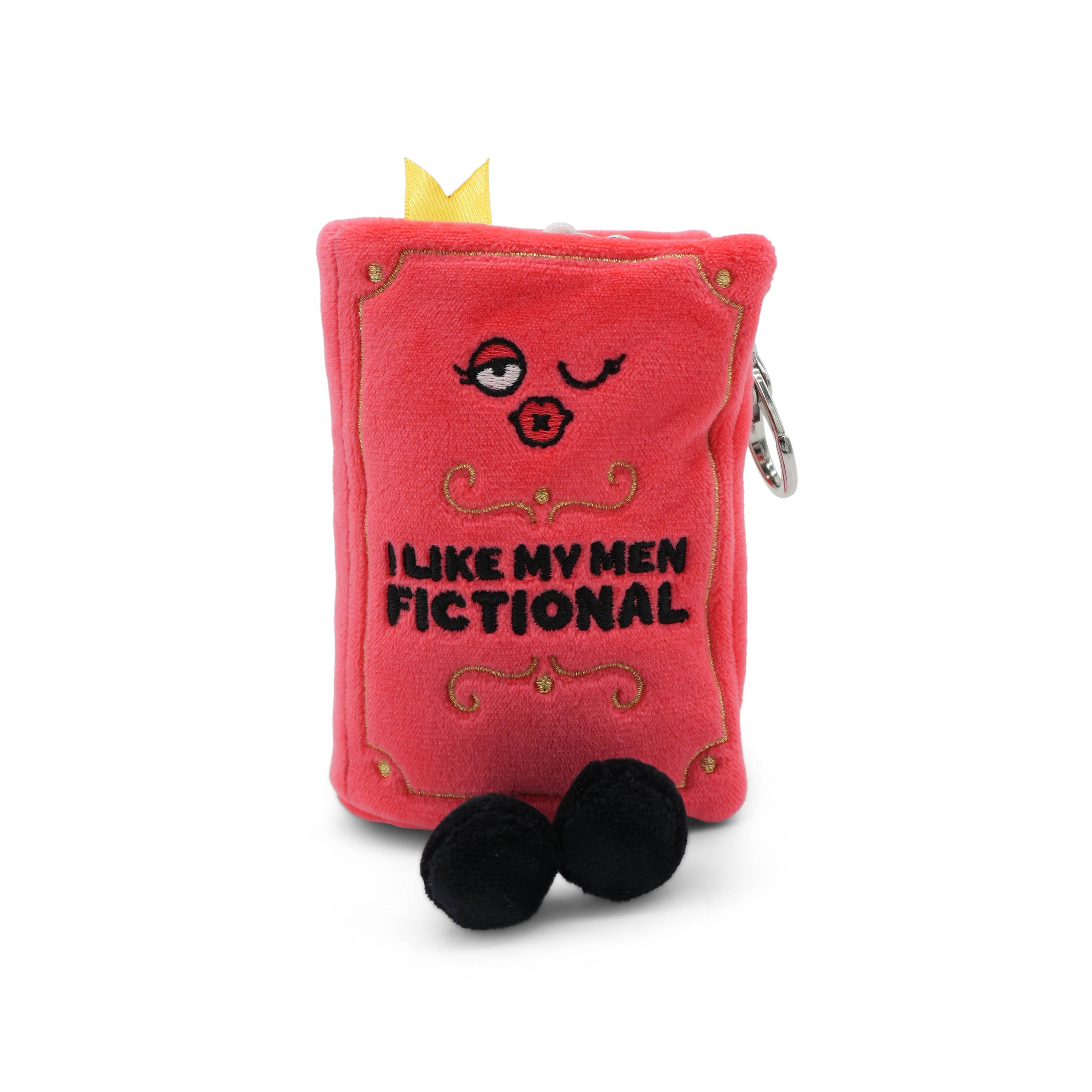 Red plush book-shaped bag charm with 'I like my men fictional' text and facial features on a white background