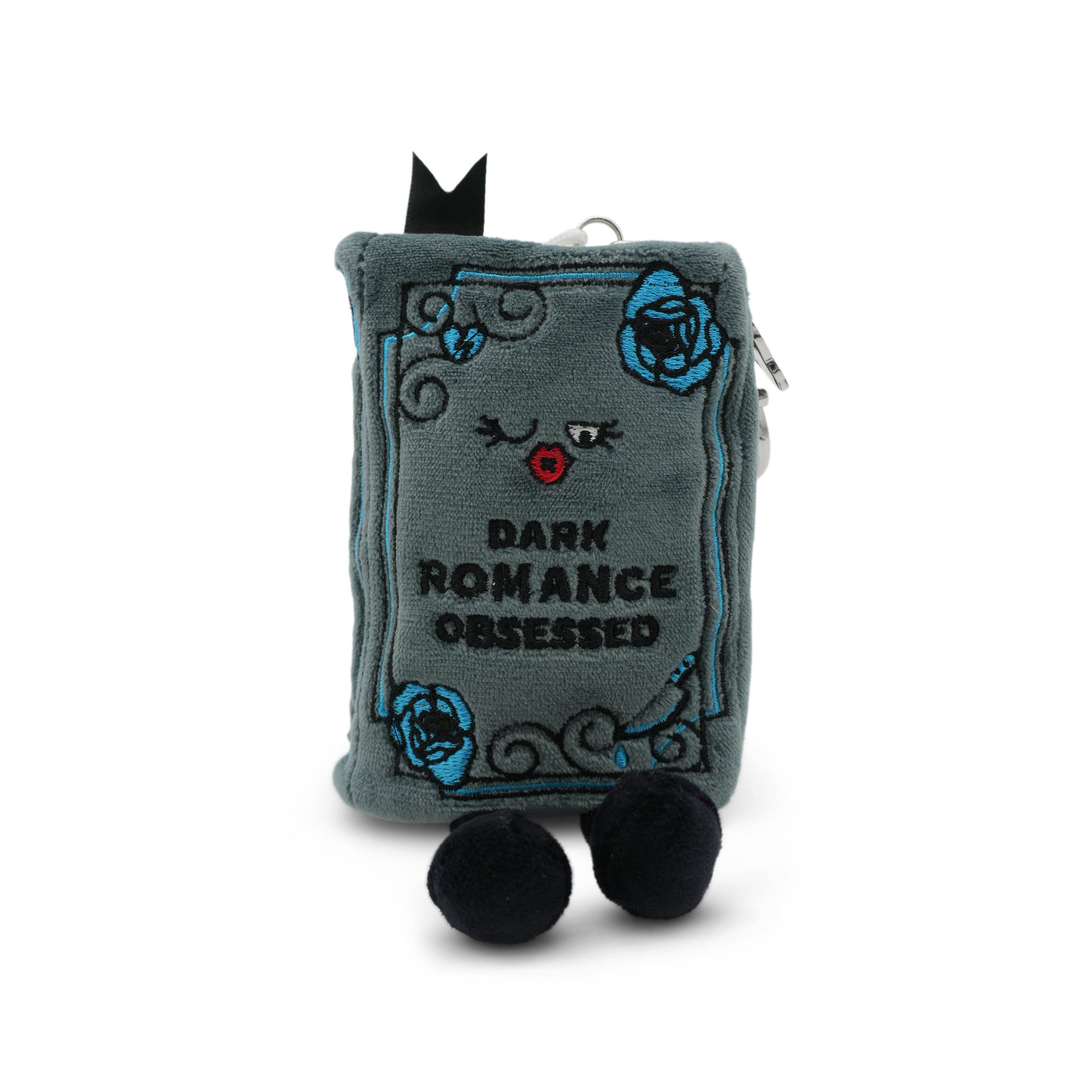 Plush bag charm shaped like a book with a face and text 'Dark Romance Obsessed' on a white background.