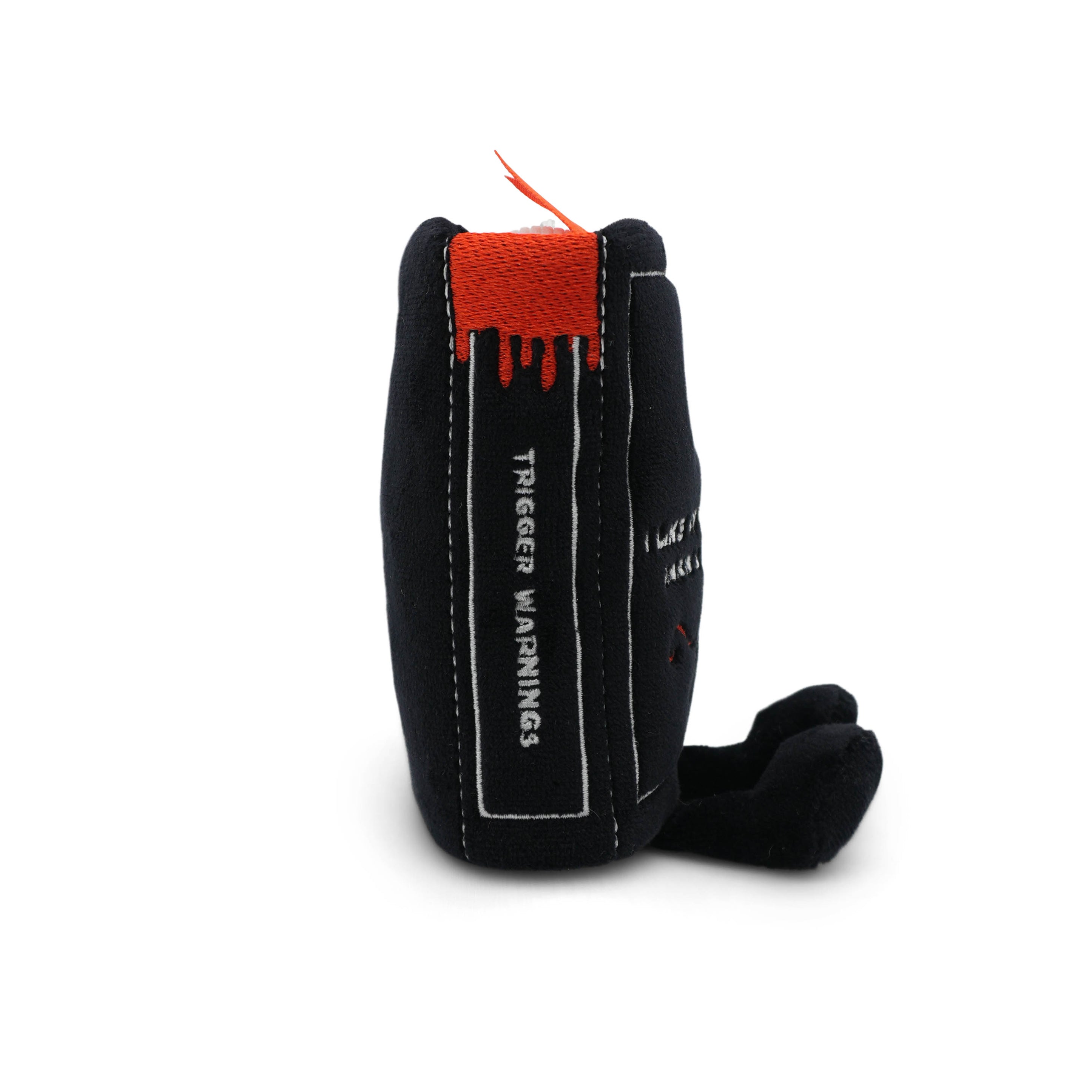 The spine of a black plush book bag charm that reads trigger warnings