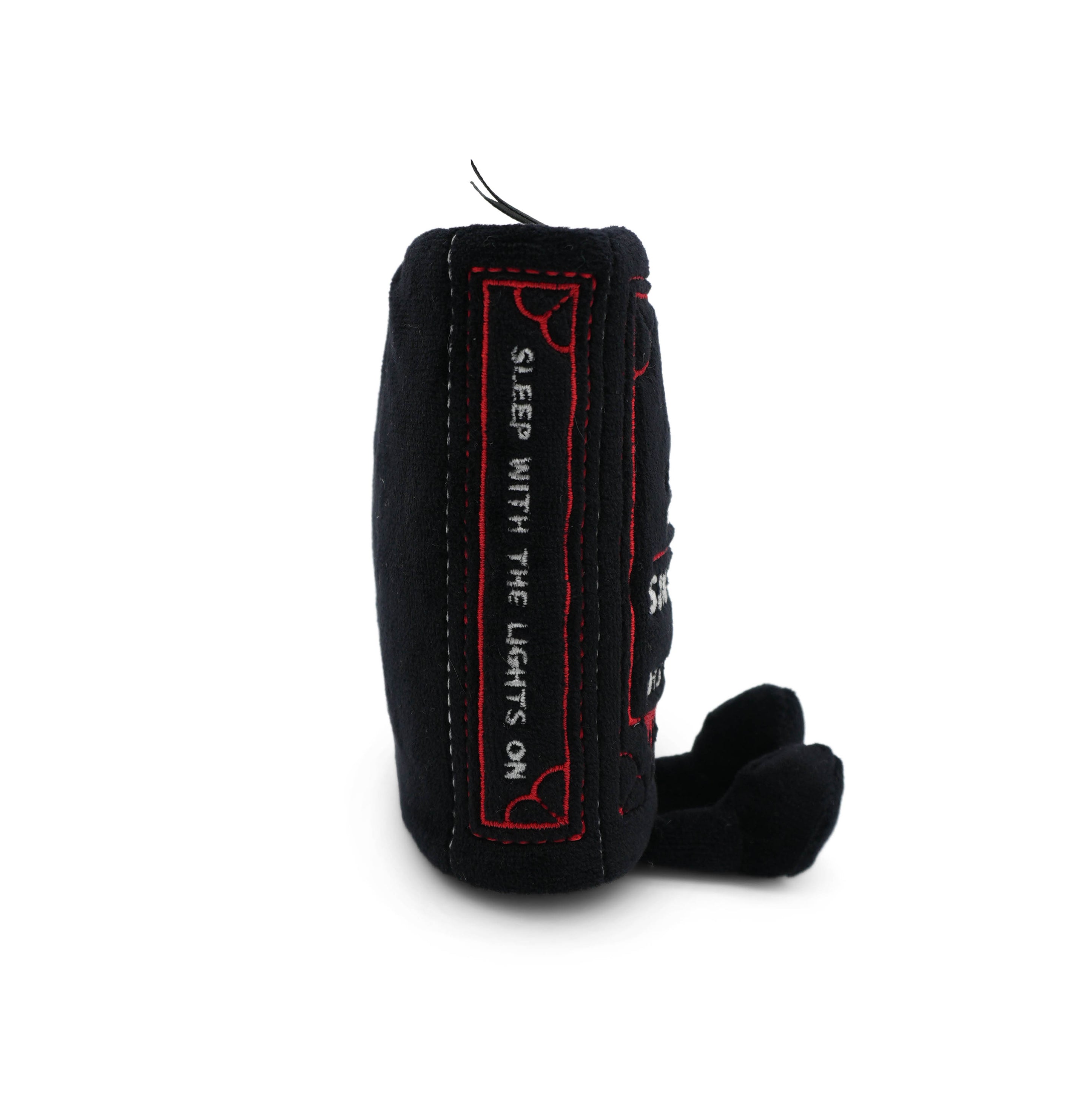 Black plush book charm with 'sleep with the light on' text written on the spine