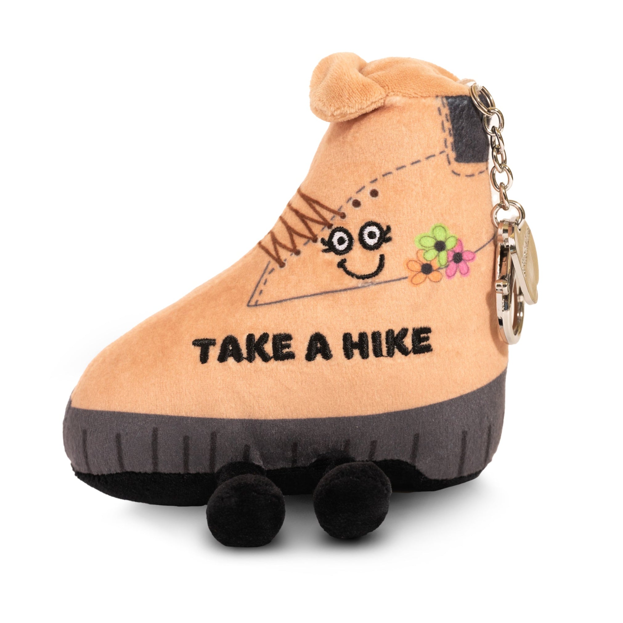 A plush bag charm shaped like a brown hiking boot with a smiling face and the phrase 'TAKE A HIKE' on it.