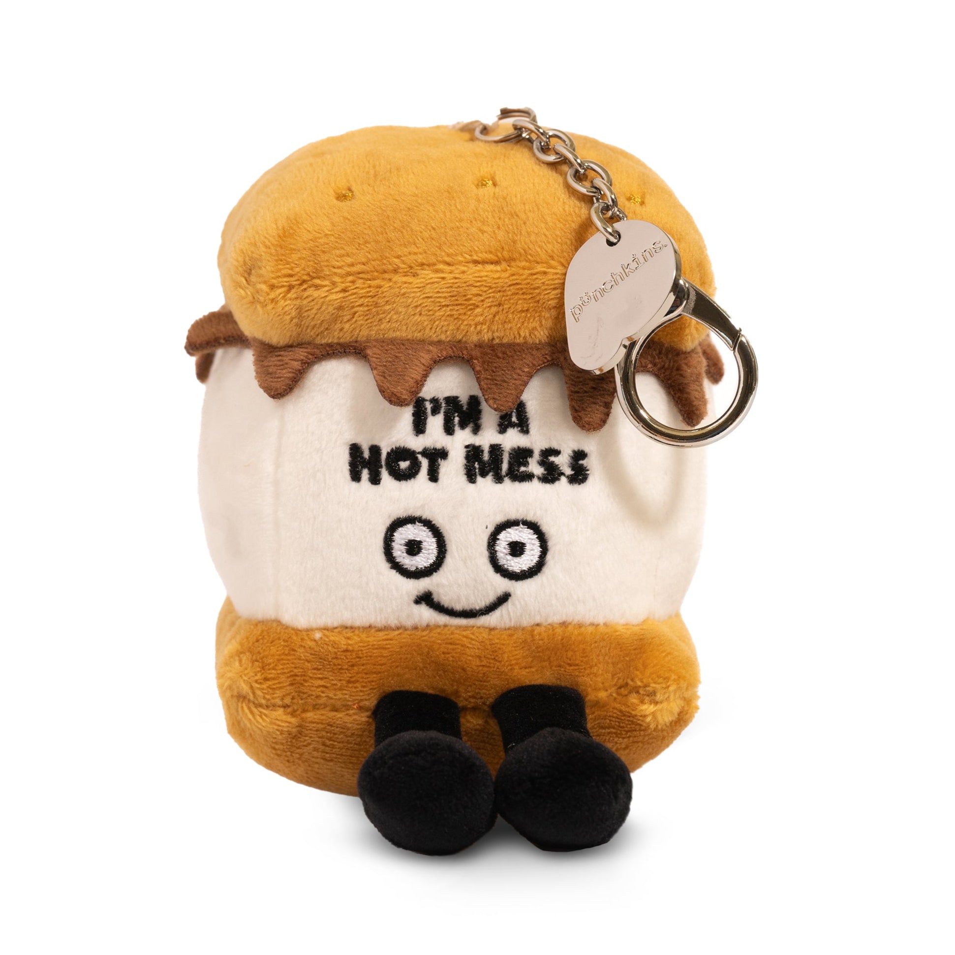 A plush bag charm designed to look like a s'more with chocolate and marshmallow elements, featuring the printed text 'I'M A HOT MESS' on it. 