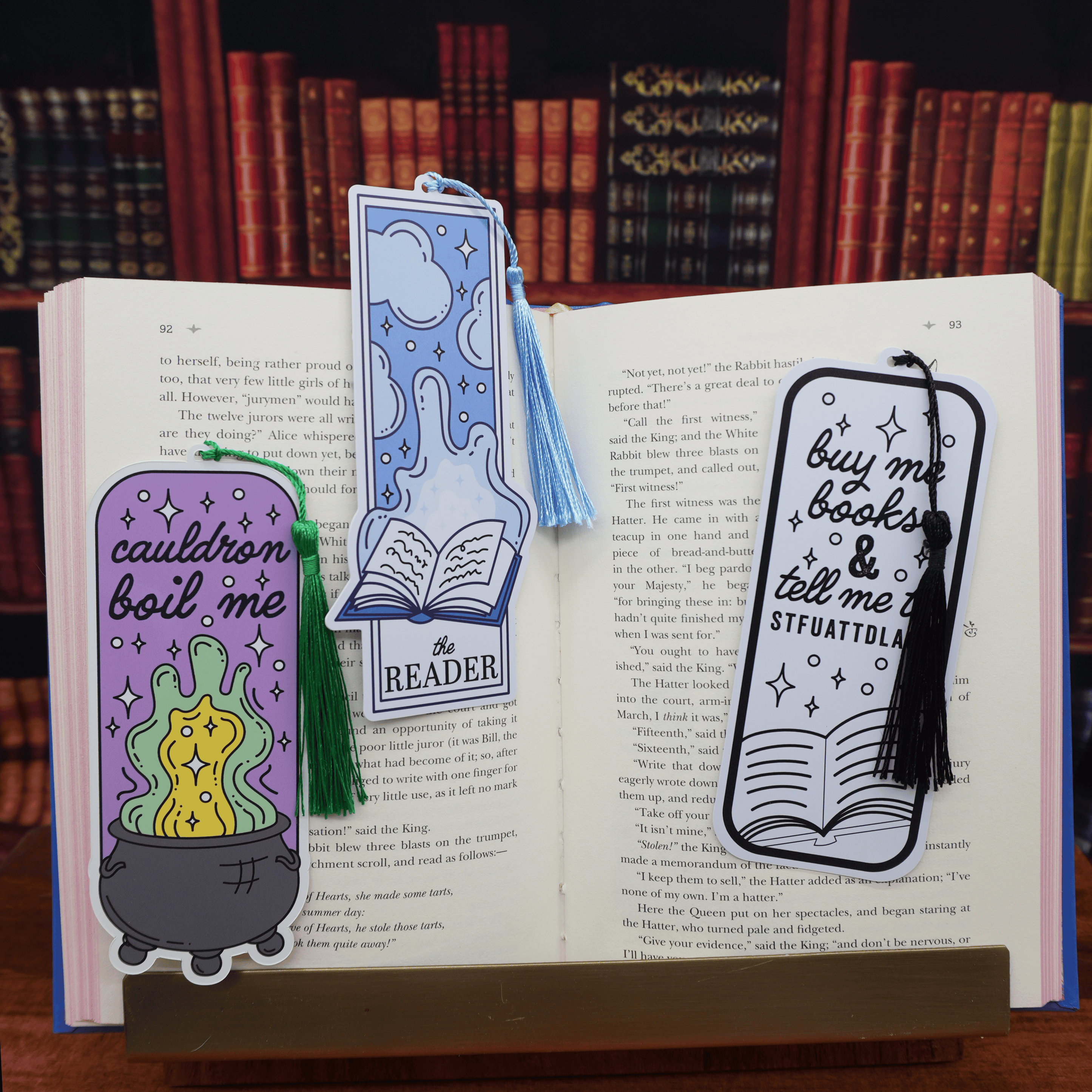 Three colorful bookmarks on an open book with a bookshelf background