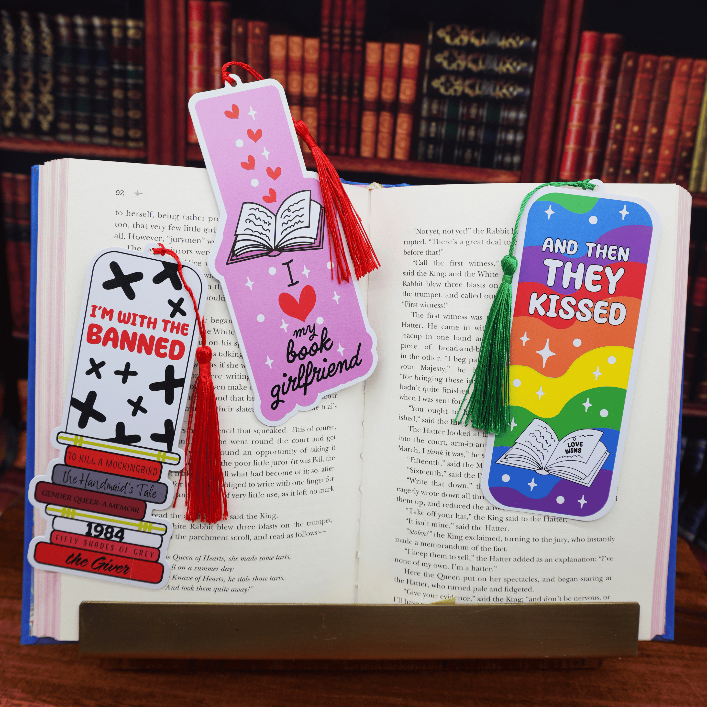 Three colorful bookmarks on an open book with a bookshelf background