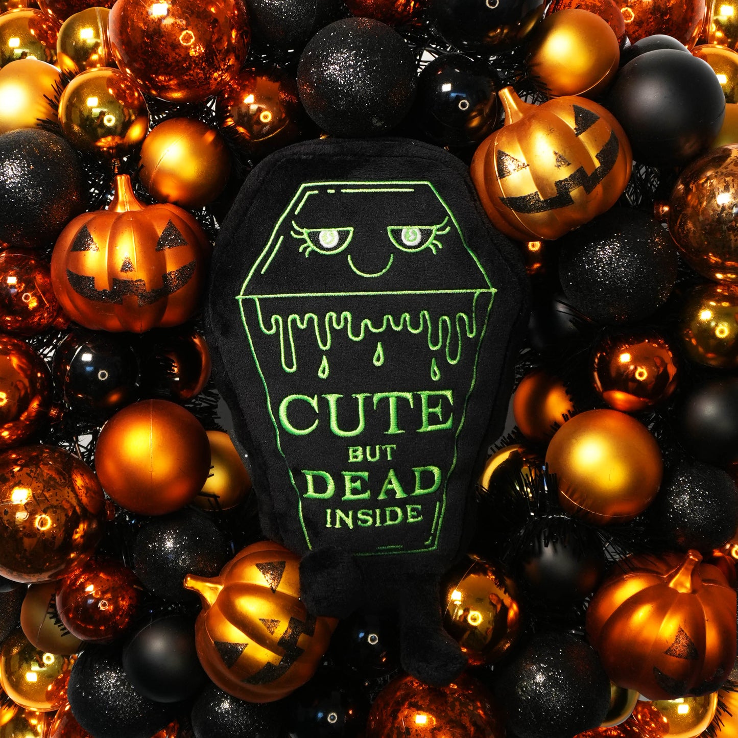 Halloween-themed plush toy with text surrounded by decorative balls and pumpkins.