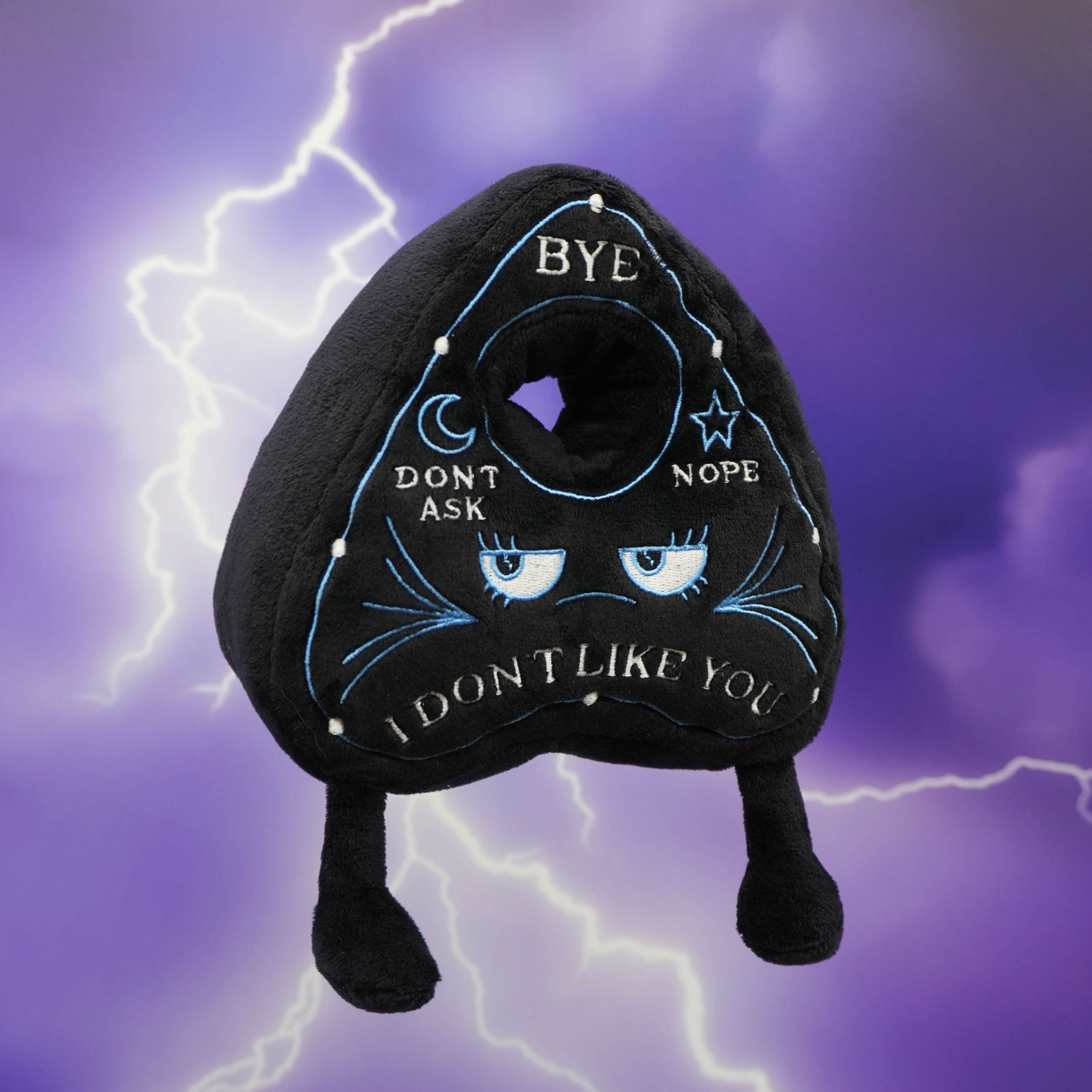 Black planchette plush toy with text on a purple background with lightning effects