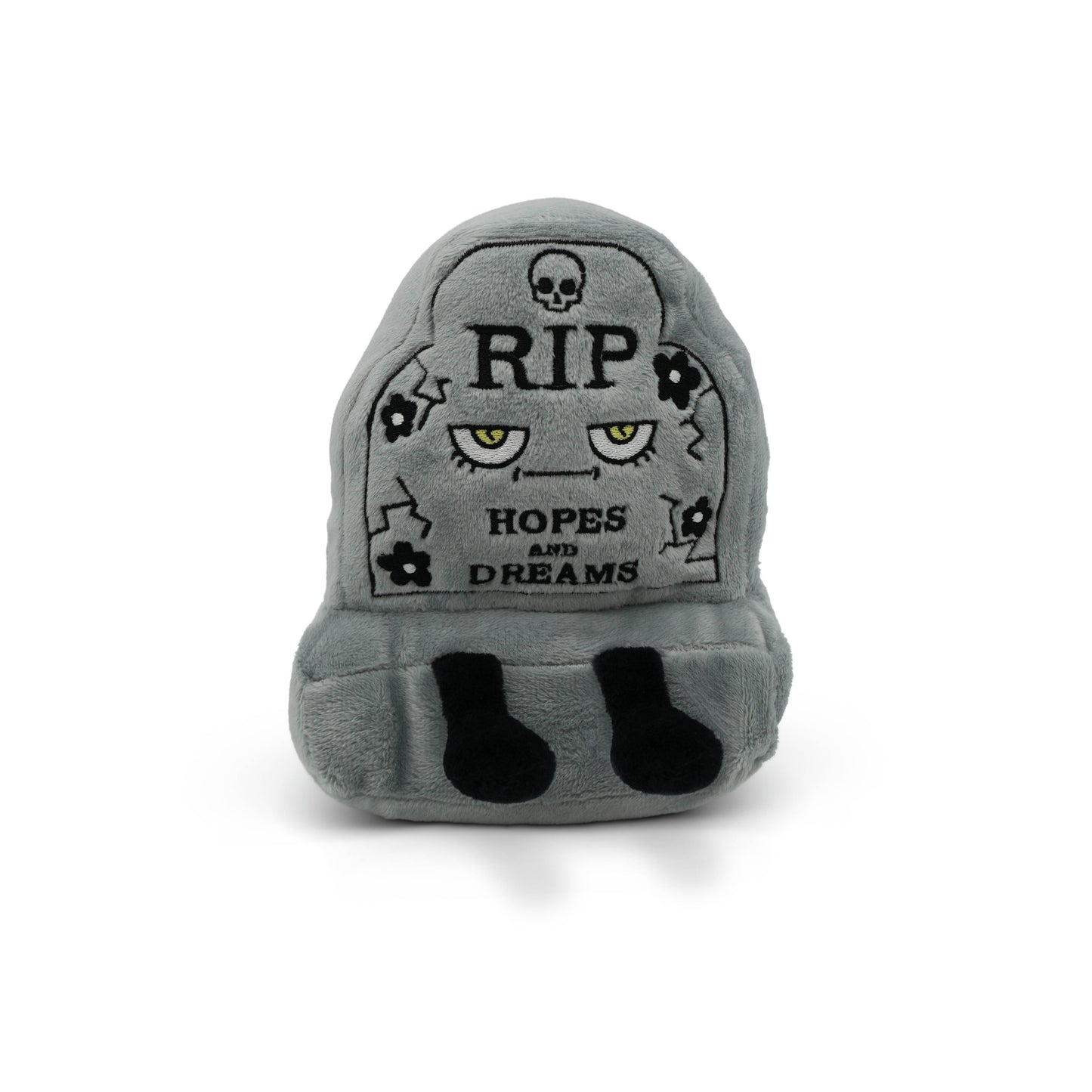 Gray plush toy shaped like a headstone with text and skull designs on a white background.