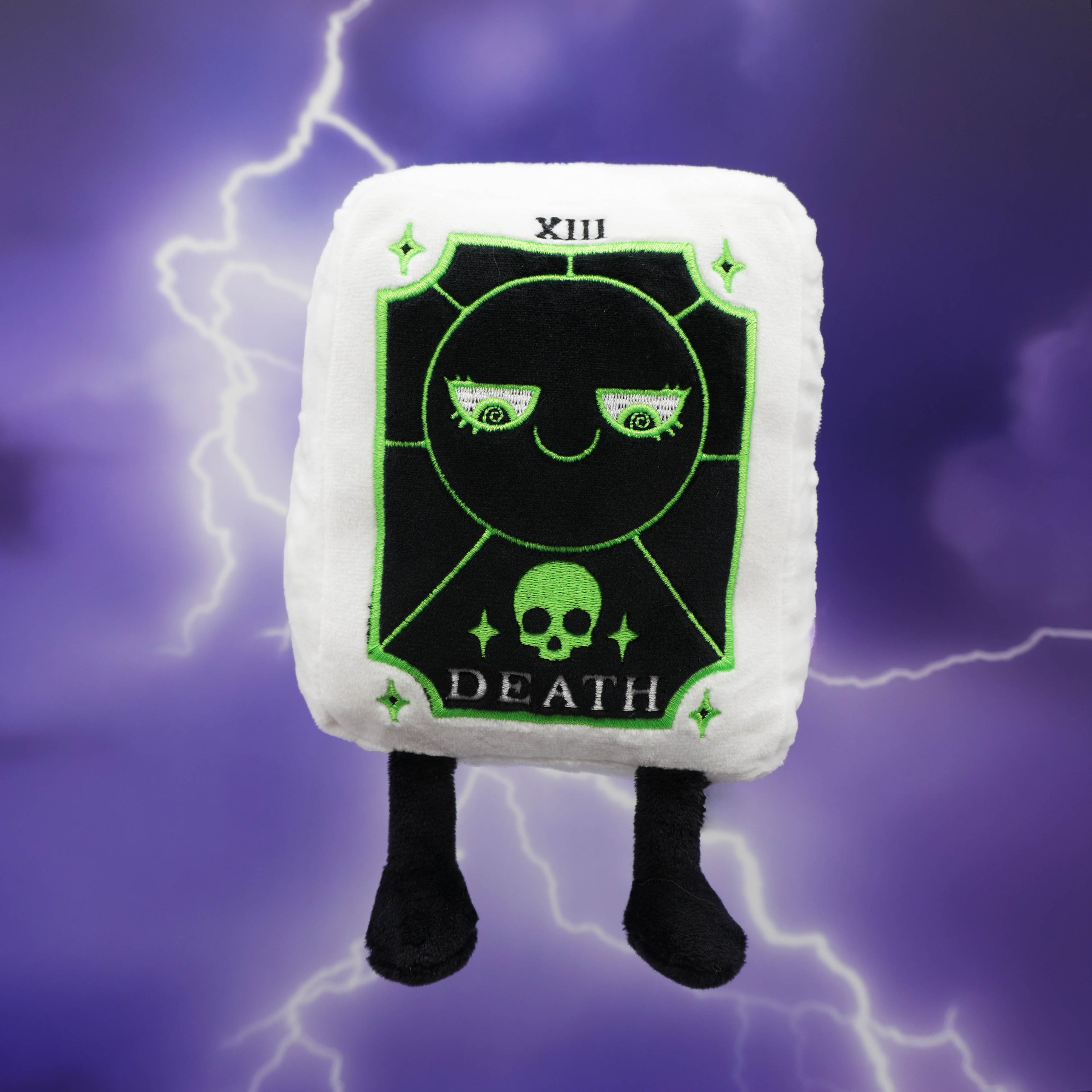 A tarot plush toy resembling the Death Card against a purple background with lightning effects. 