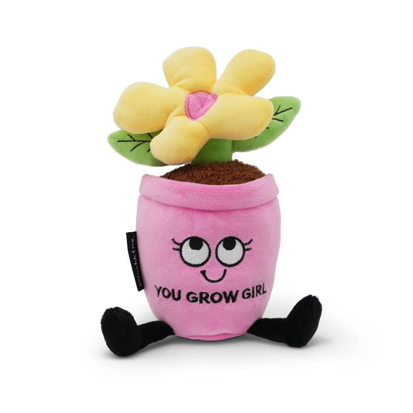 Plush toy with a pink pot and yellow flower with the phrase "You grow, girl" witten on it on a white background