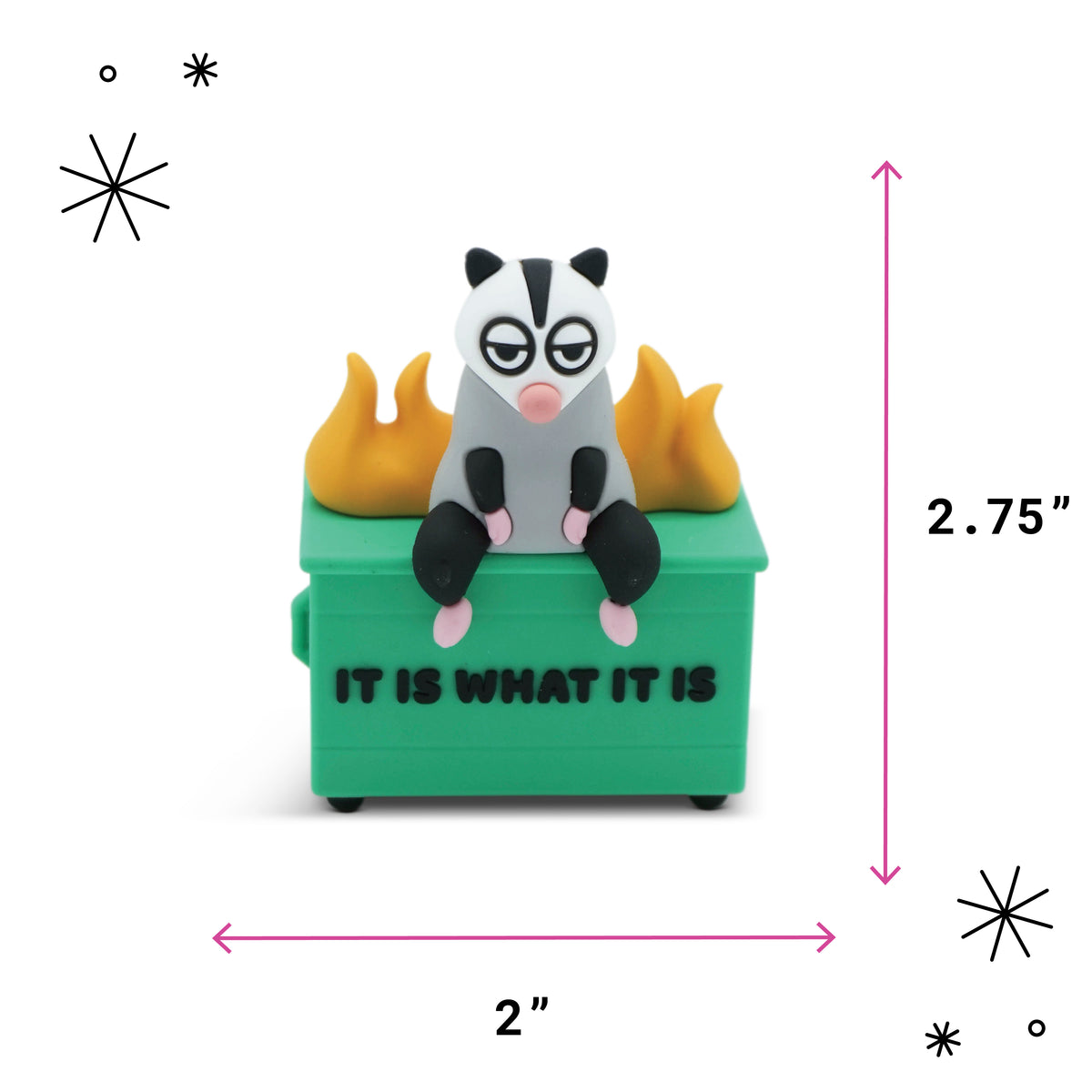 A small figurine of a smug gray and black animal sitting on a green dumpster with yellow flames, shown with dimension arrows and labels reading 2.75 inches tall, 2 inches wide, and pink measurement markers on a white background.