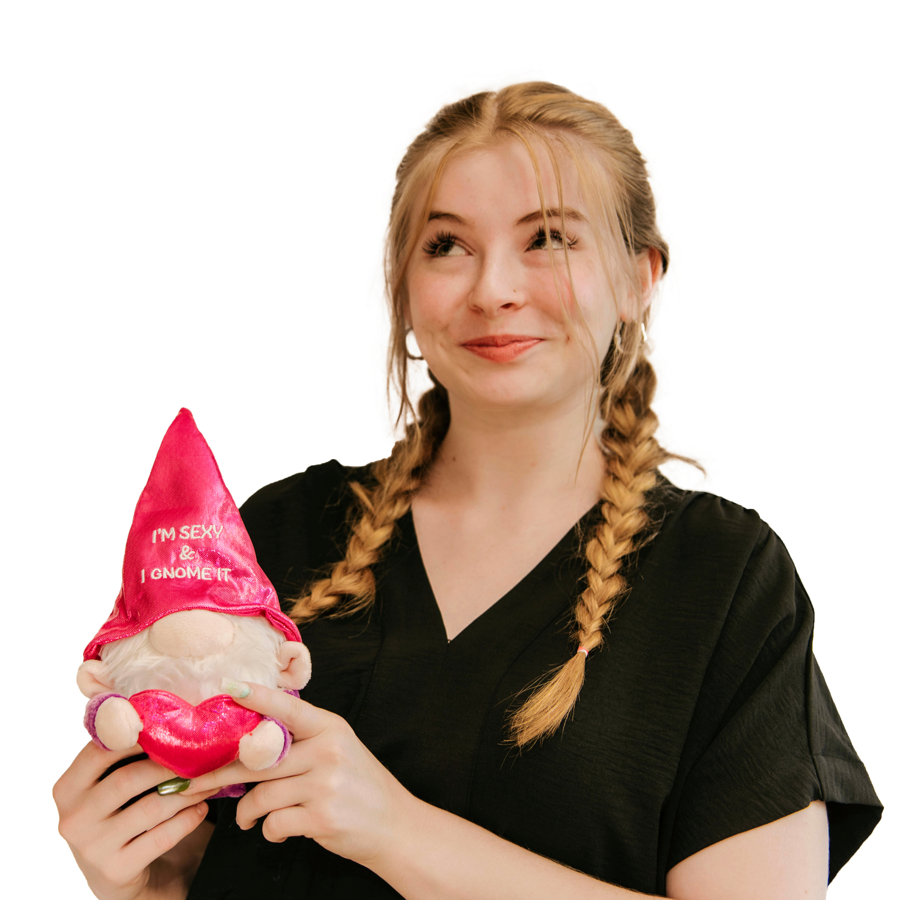 A model holding a plush gnome with a shiny pink hat that says 'I'm Sexy and I Gnome It' on it.