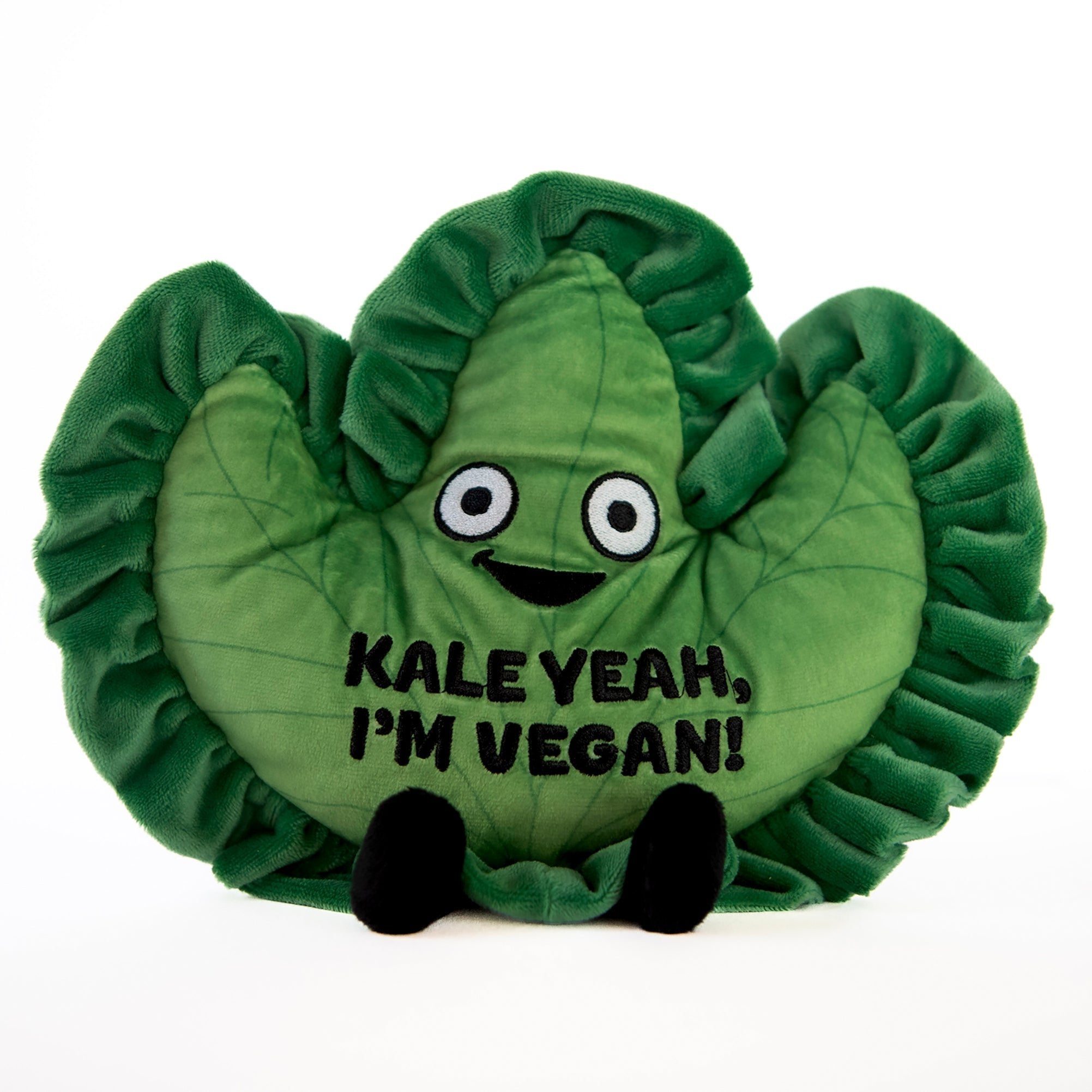 A plush shaped like a kale leaf with a smiling face and the text 'KALE YEAH, I'M VEGAN!' on it.