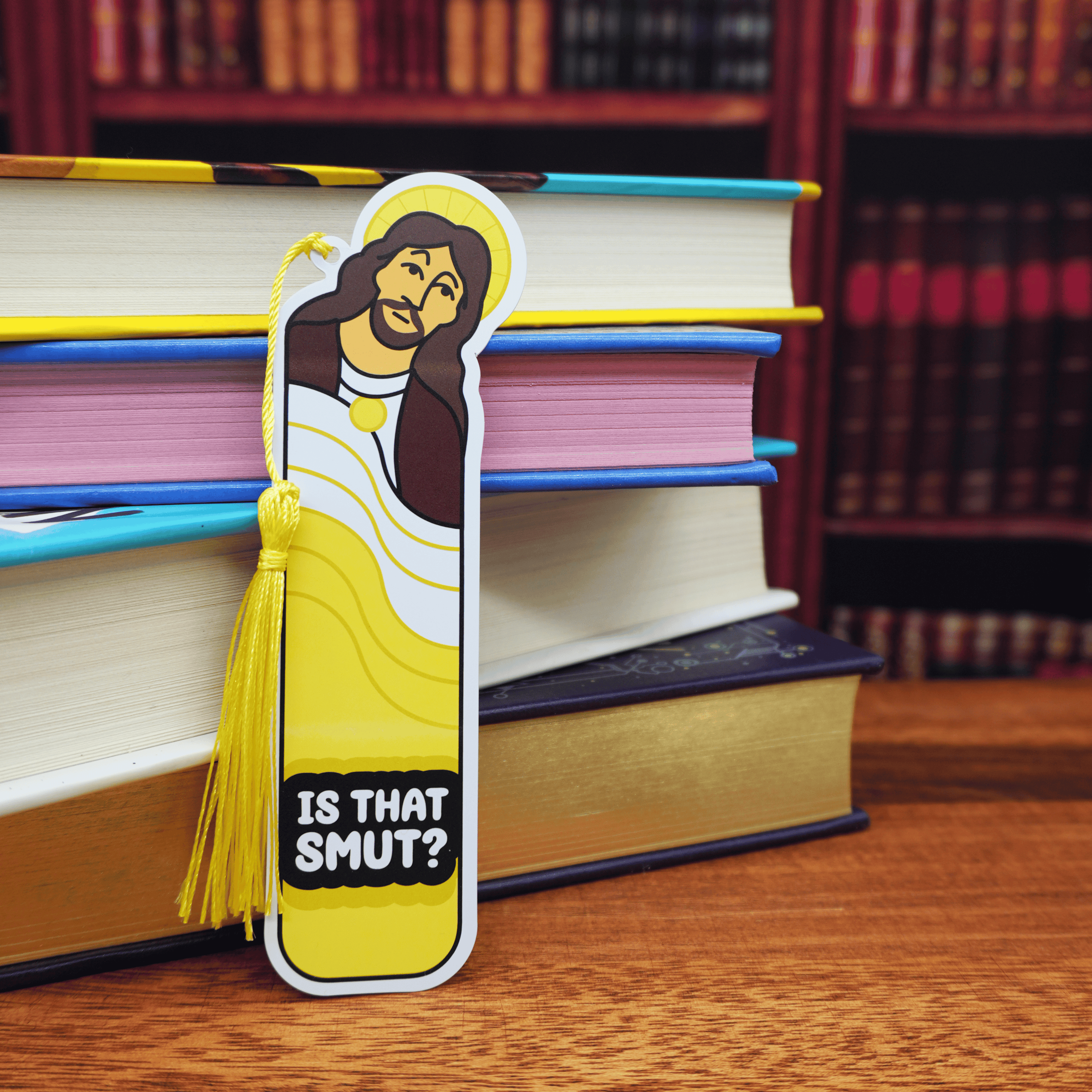 Bookmark of Jesus saying, 'Is that smut?' placed in front of stacked books.