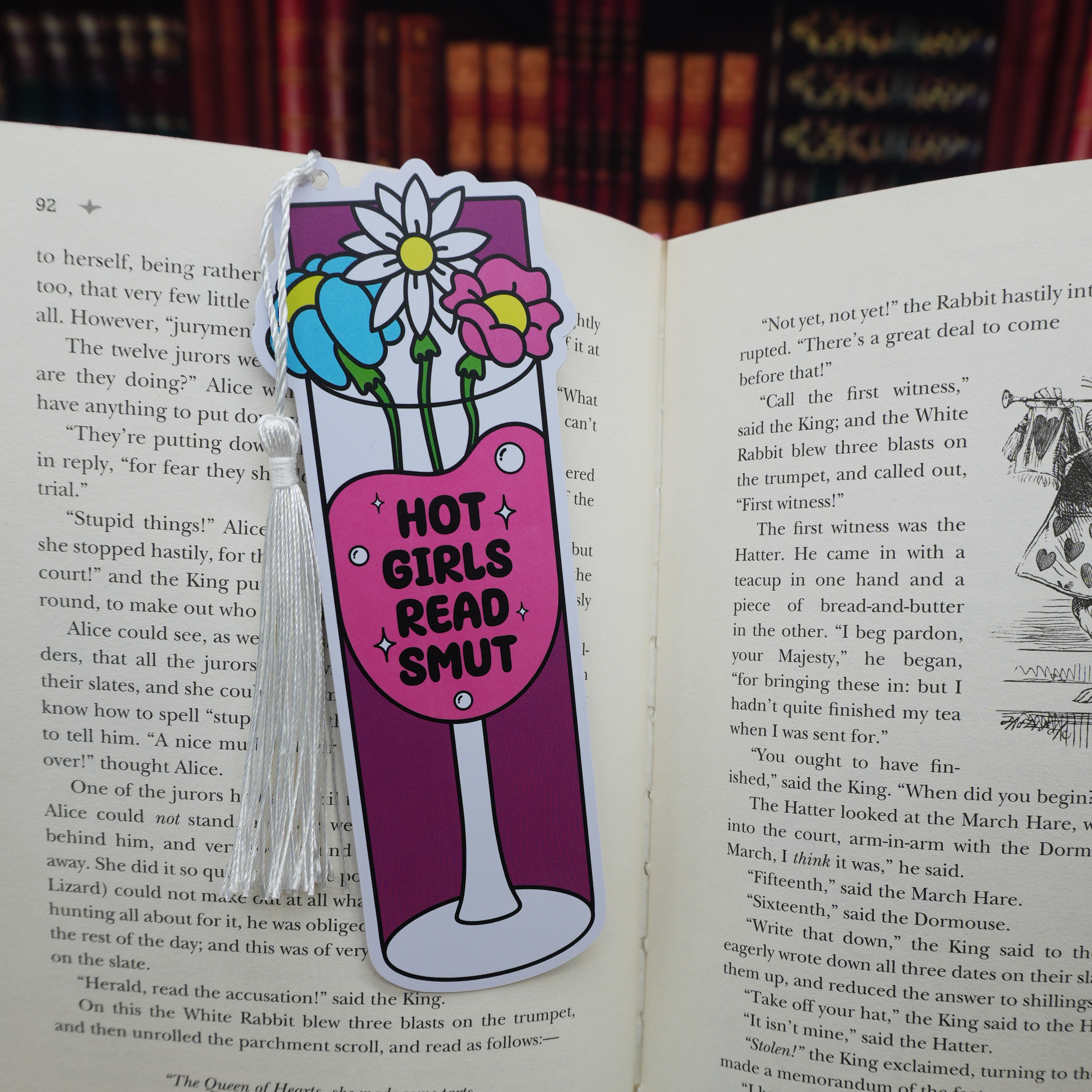 Bookmark with floral design, a wine glass, and text 'Hot Girls Read Smut' on an open book