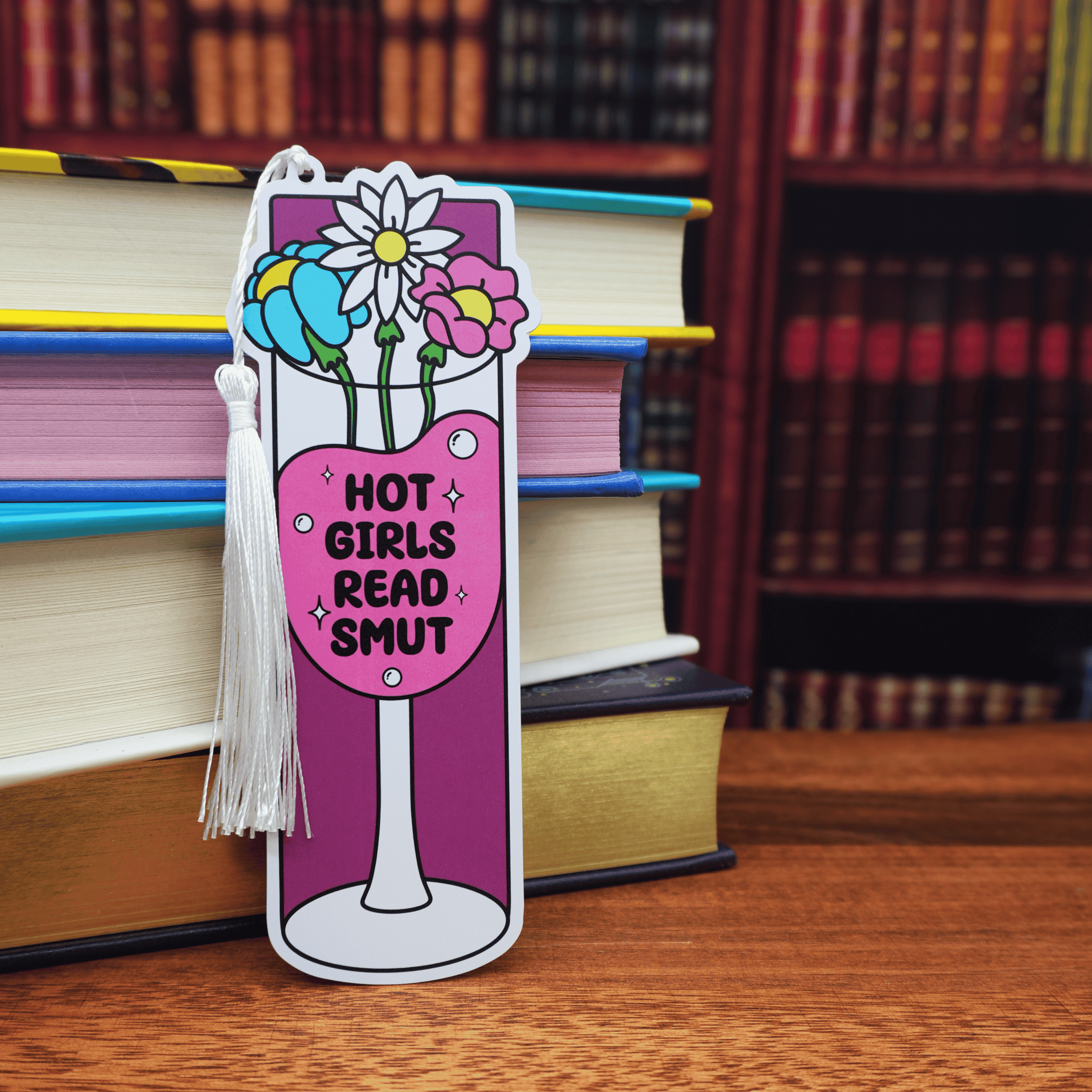 Bookmark with floral design, wine glass, and the text 'Hot Girls Read Smut' on a stack of books.