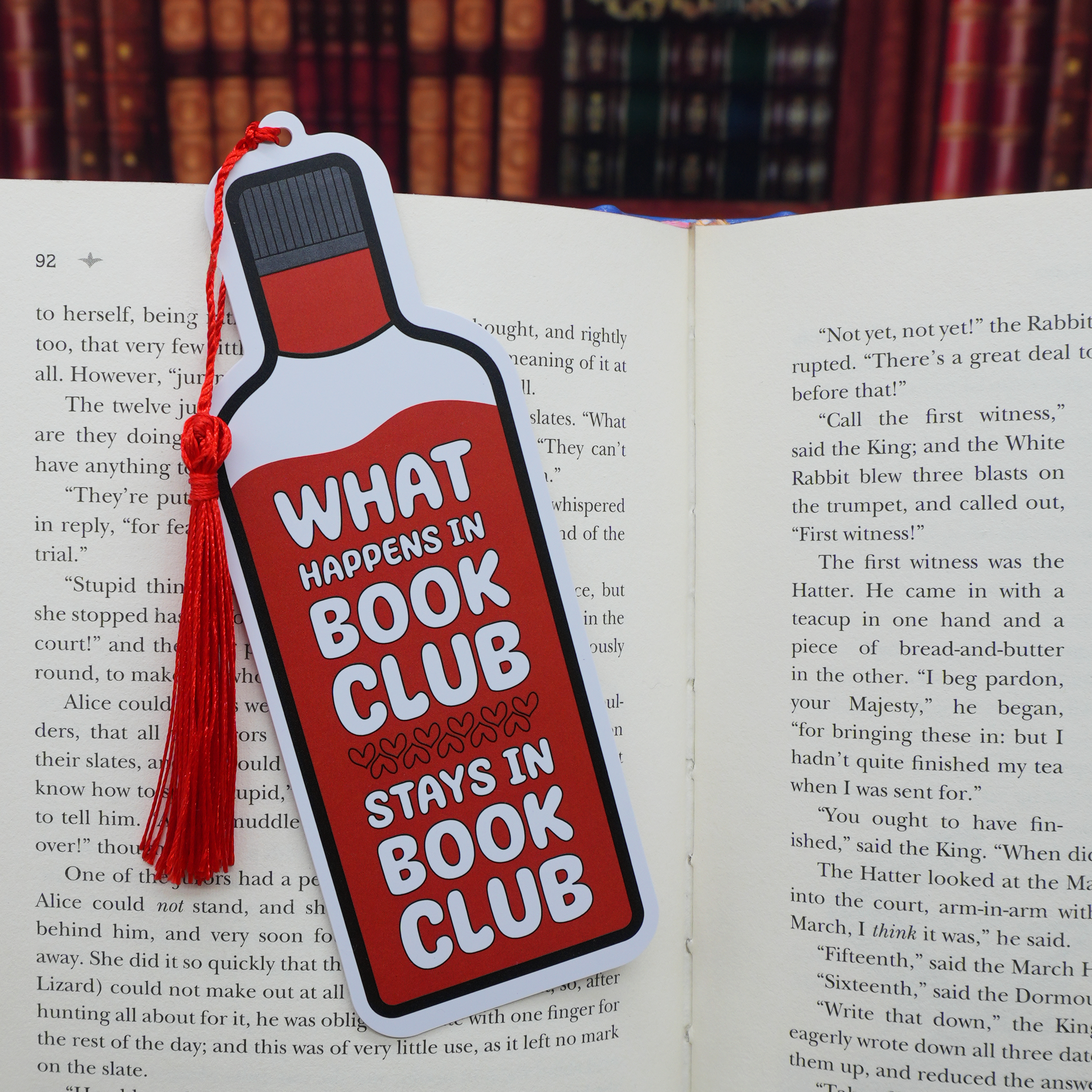 Bookmark with 'What Happens in Book Club Stays in Book Club' text on an open book.