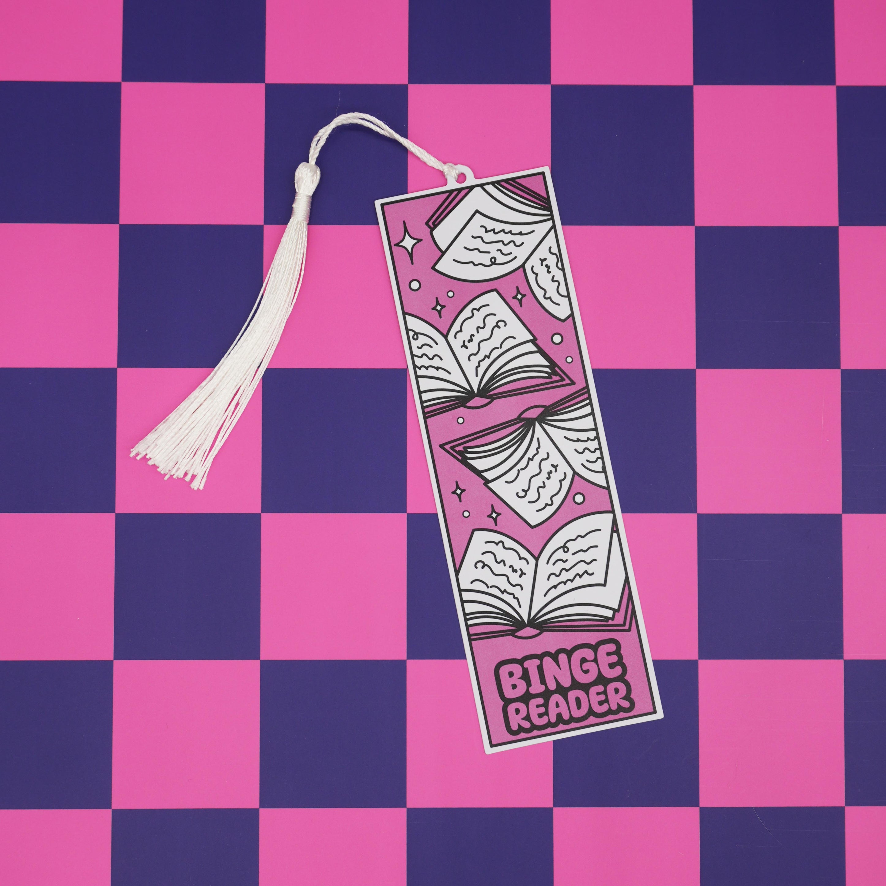 Bookmark with tassel labeled 'Binge Reader' on a pink and purple checkered background