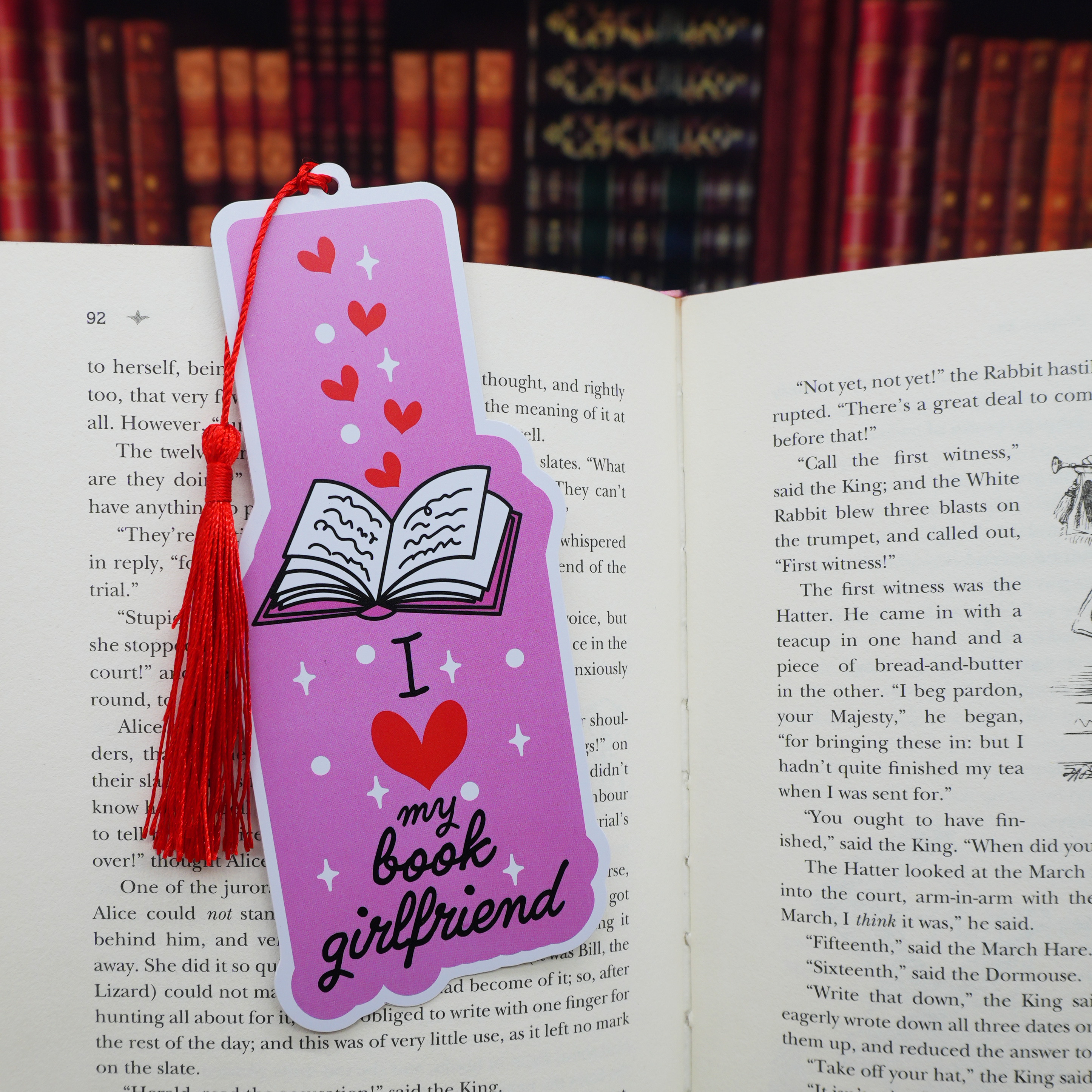 Pink bookmark with tassel on an open book, featuring 'I love my book girlfriend' text.