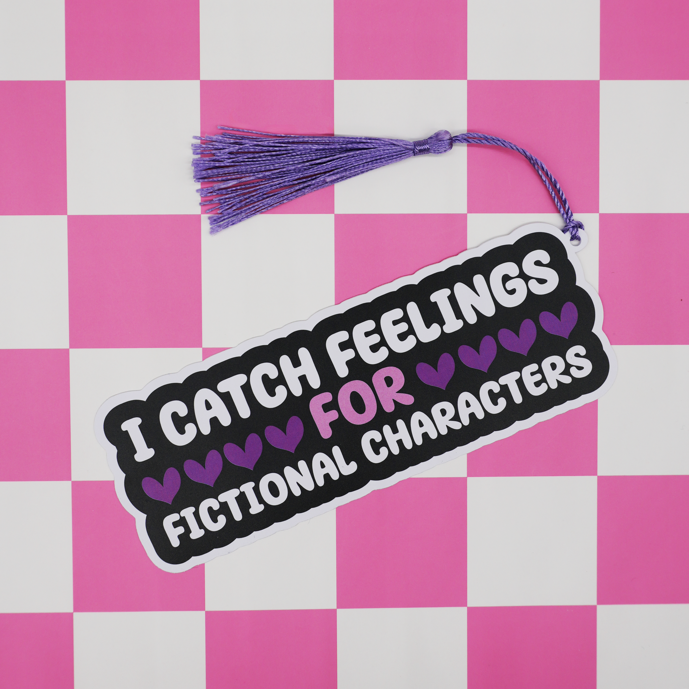 Bookmark with text 'I catch feelings for fictional characters' on a pink and white checkered background
