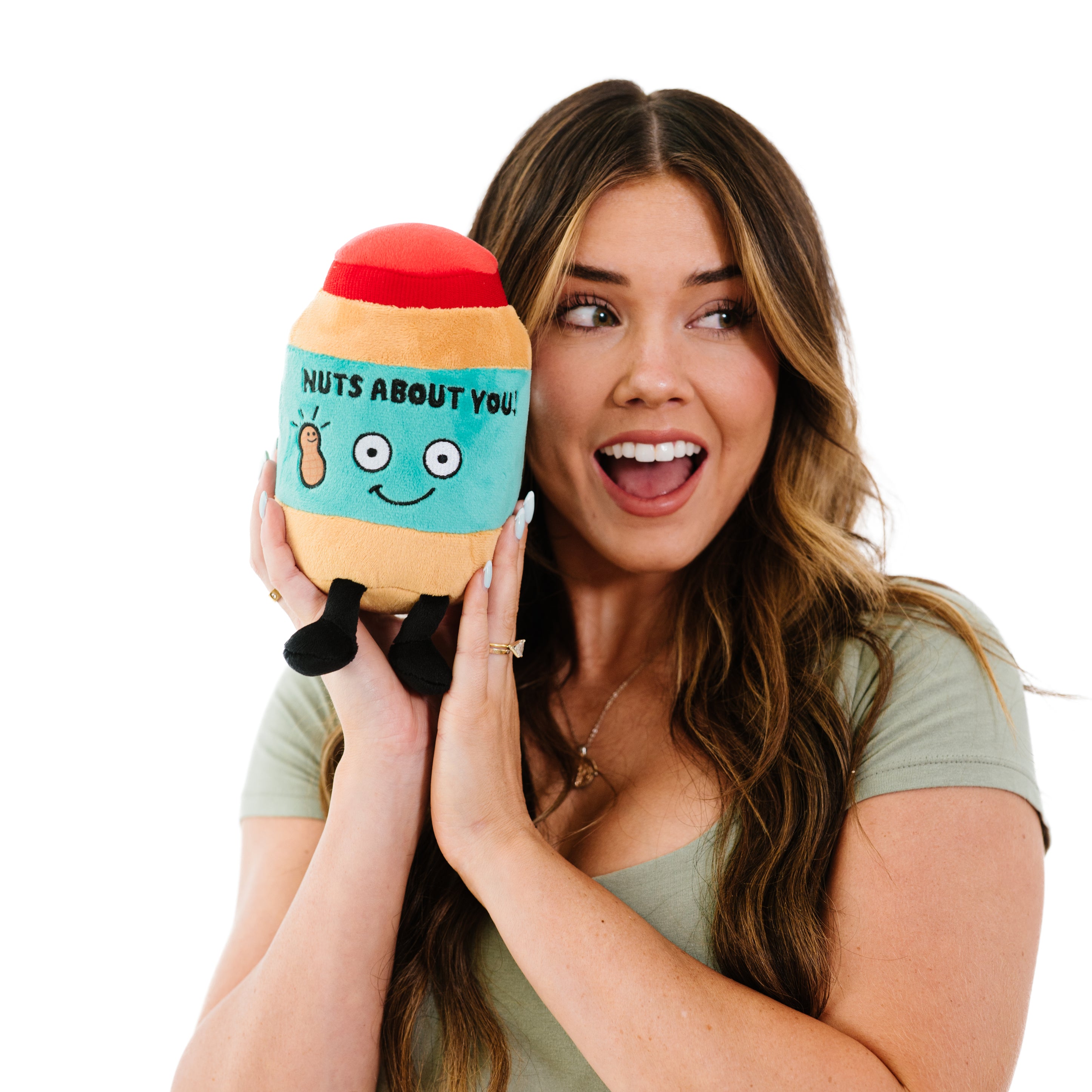 A woman holding a plush that looks like a jar of peanut butter.