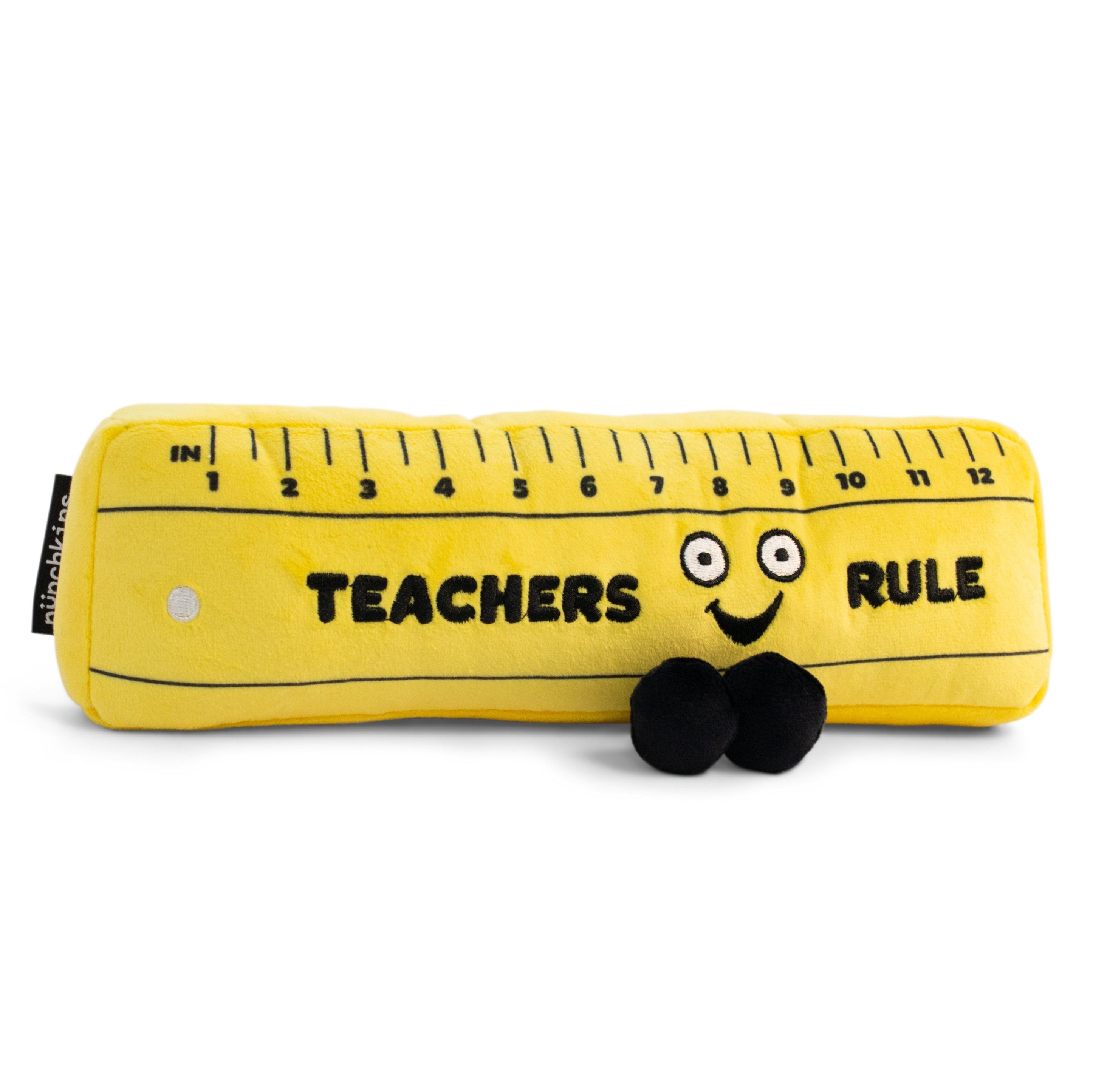 A plush shaped like a yellow ruler with a face and feet, featuring the text 'TEACHERS RULE' on the top.