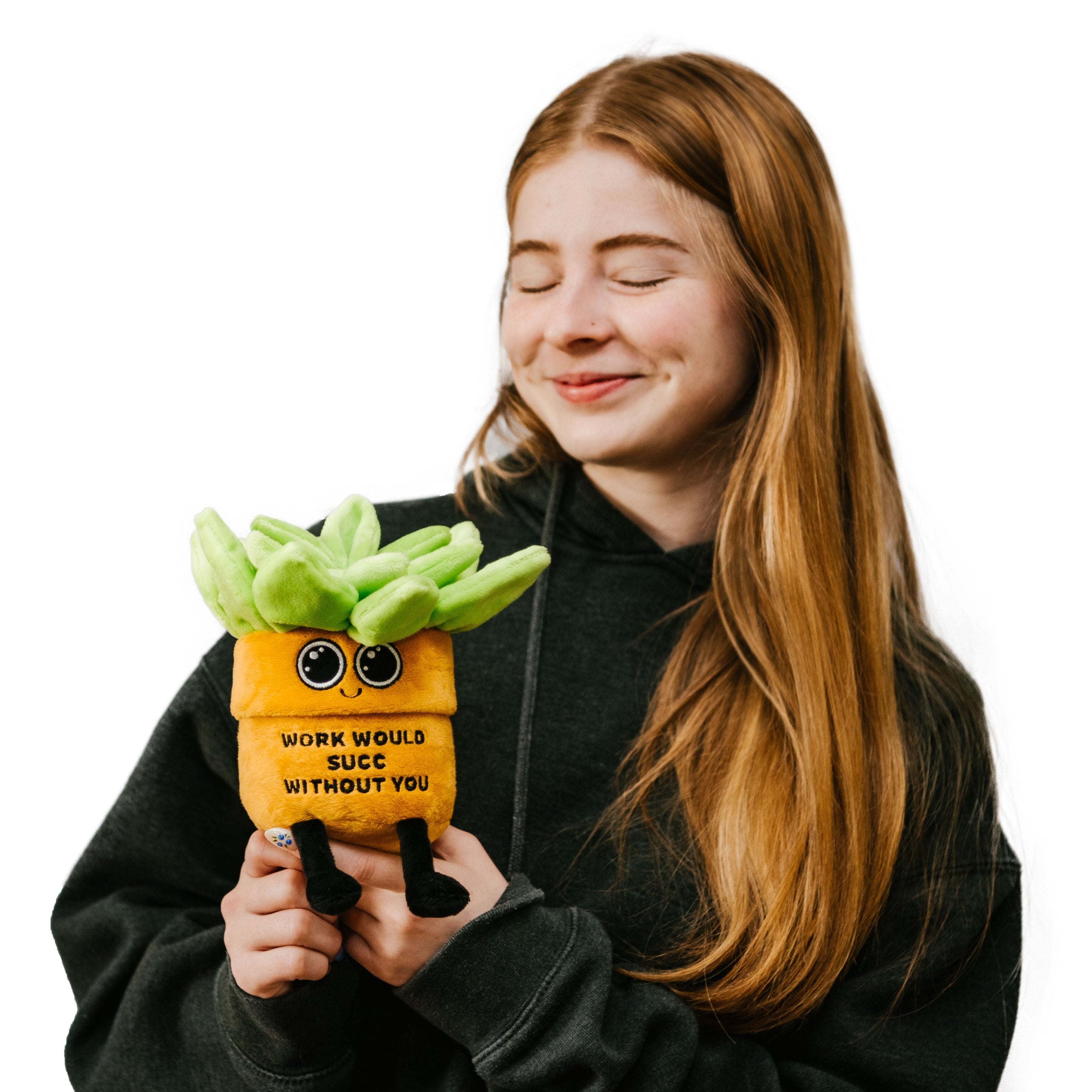 A model holding a plush designed to look like a plant with text on its base saying, 'WORK WOULD SUCC WITHOUT YOU'.