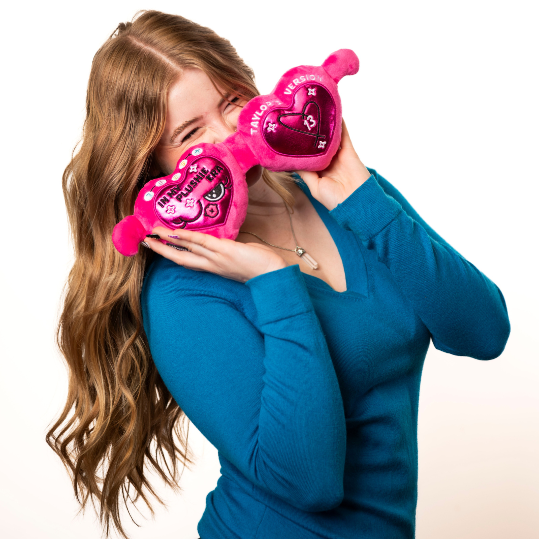 A model holding a plush resembling pink sunglasses with text that reads, "In my plushie era" up to her face.