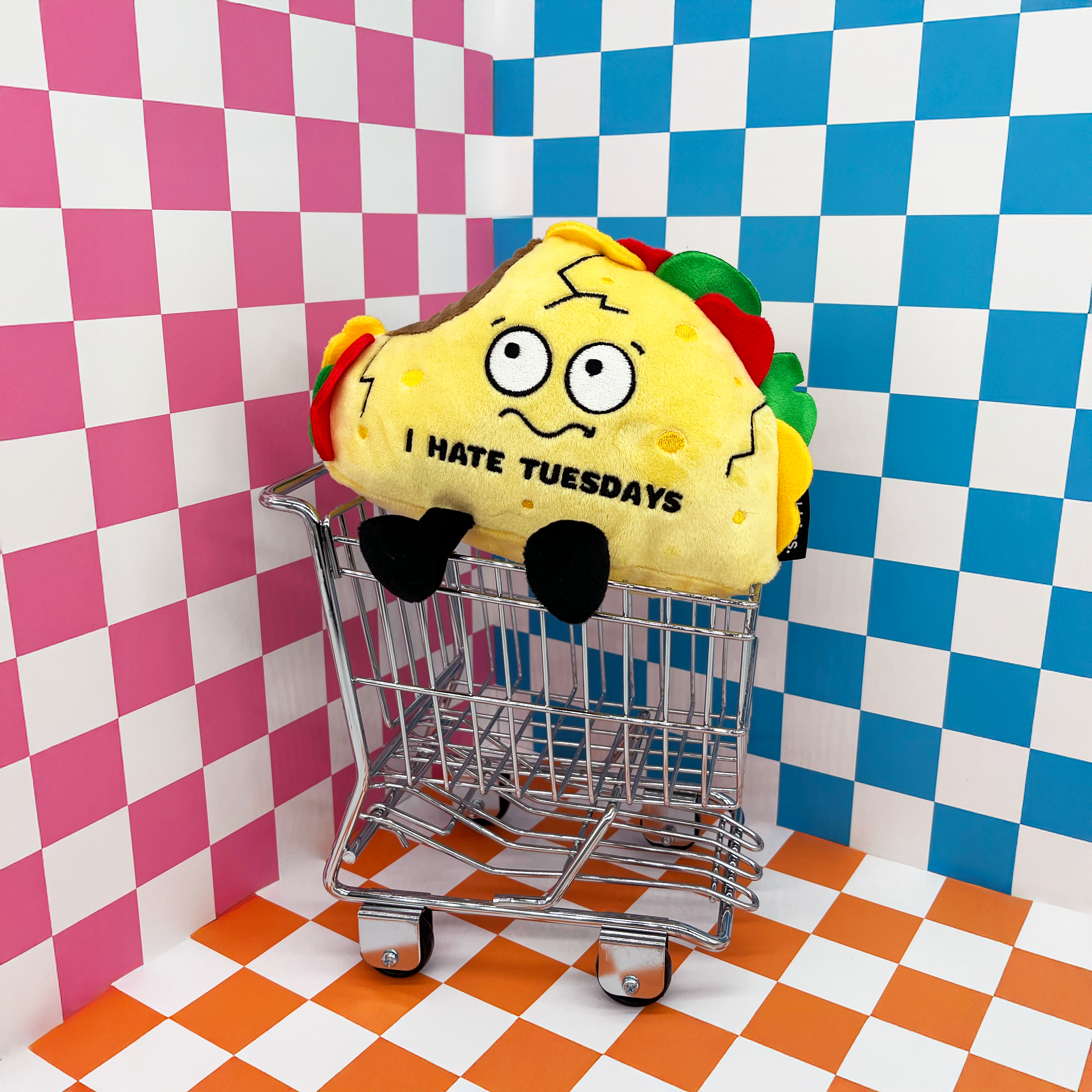 A plush taco placed in a mini shopping cart.