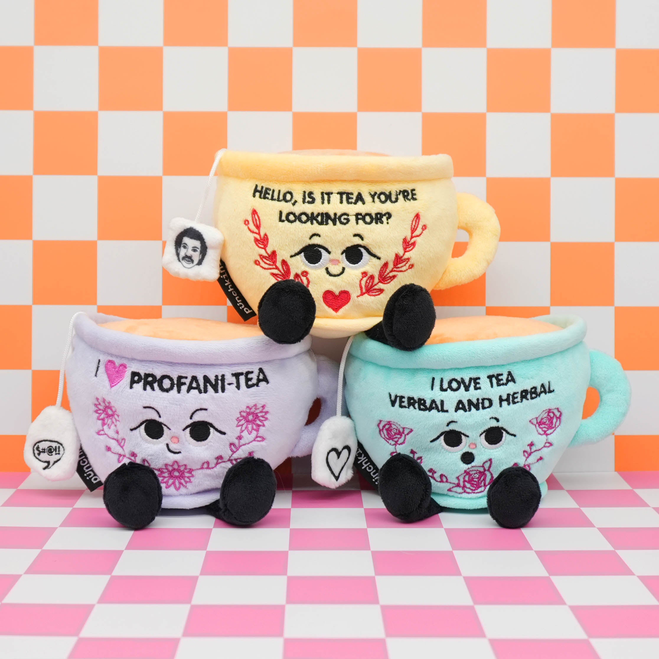 Three plush teacups on a checkered background.